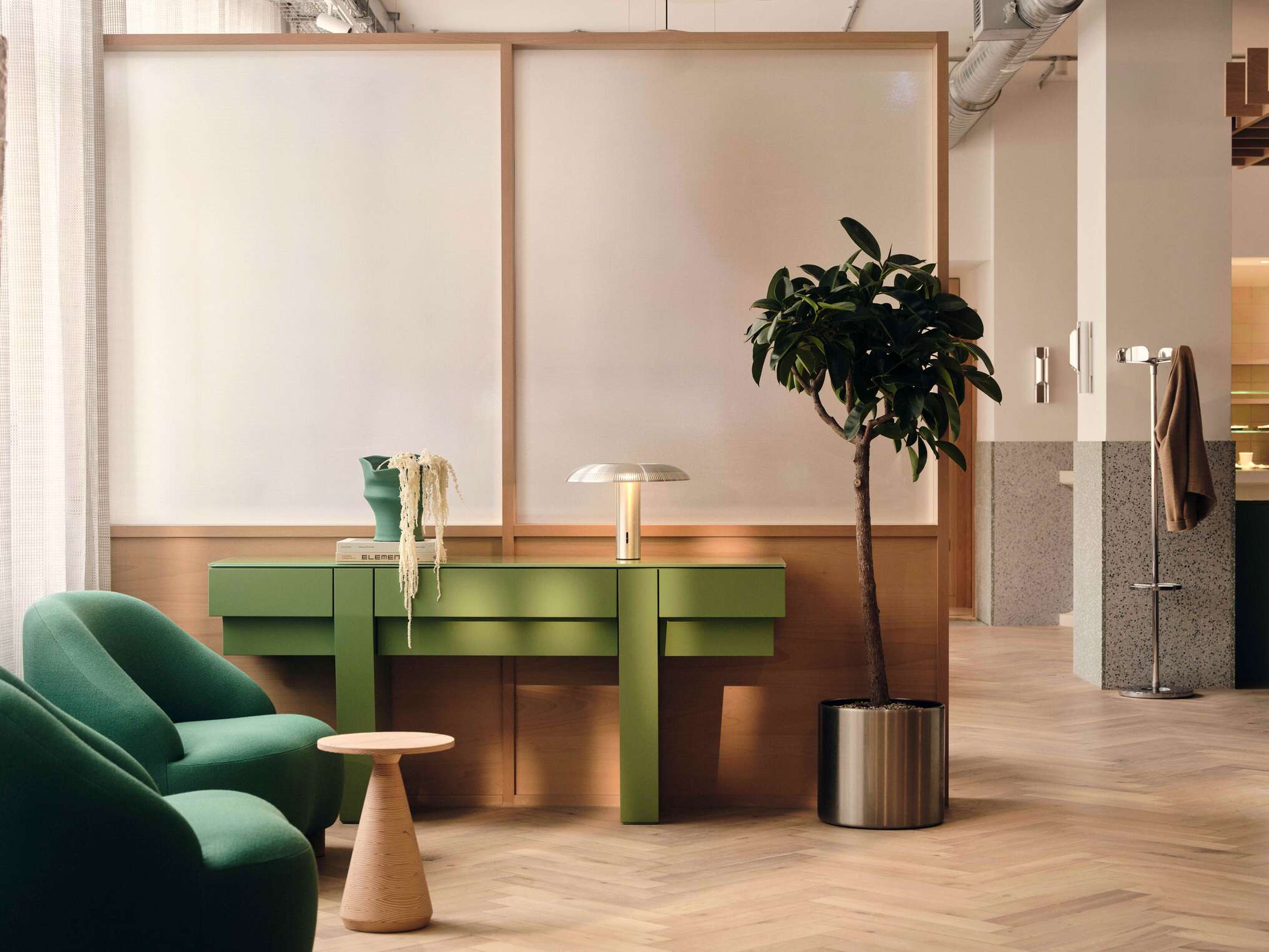 Modus designed Henry Wood House reception area with green seating, plants and partitions.