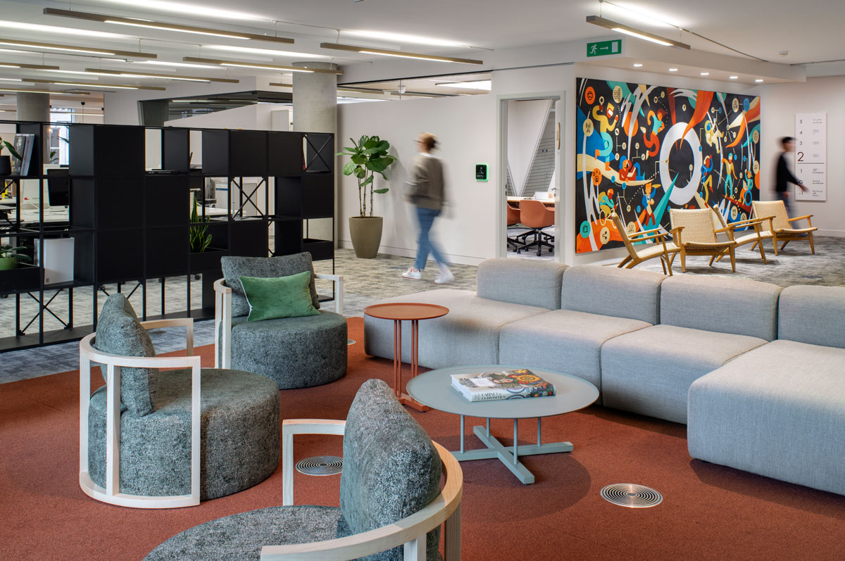 A vibrant lounge area at Publicis Sapient’s London office, featuring comfortable seating and a colourful mural.