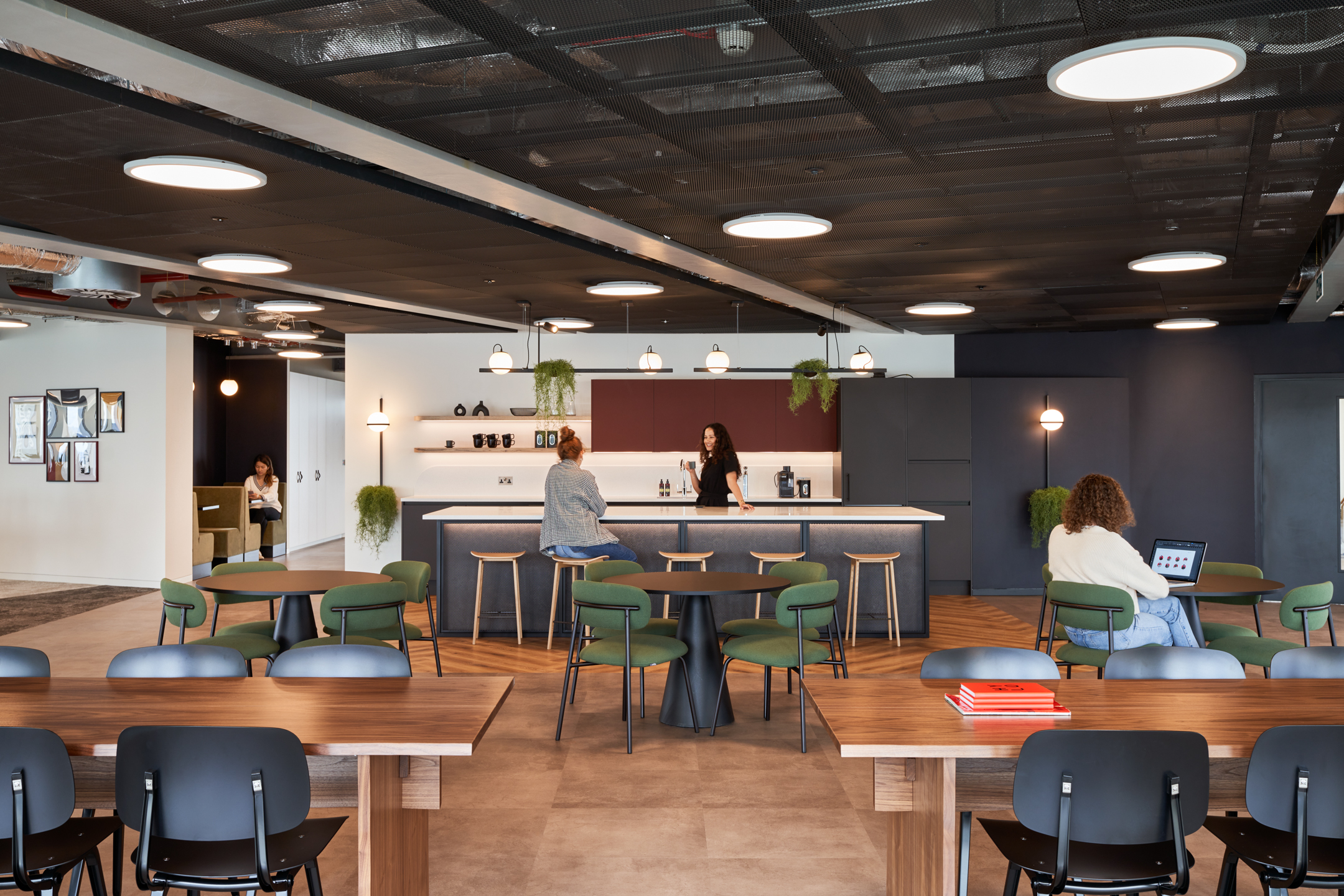 -A spacious teapoint in HYLO’s Tenant-Ready™ office featuring a central bar and seating area. This social hub is designed to encourage team interaction and collaboration.