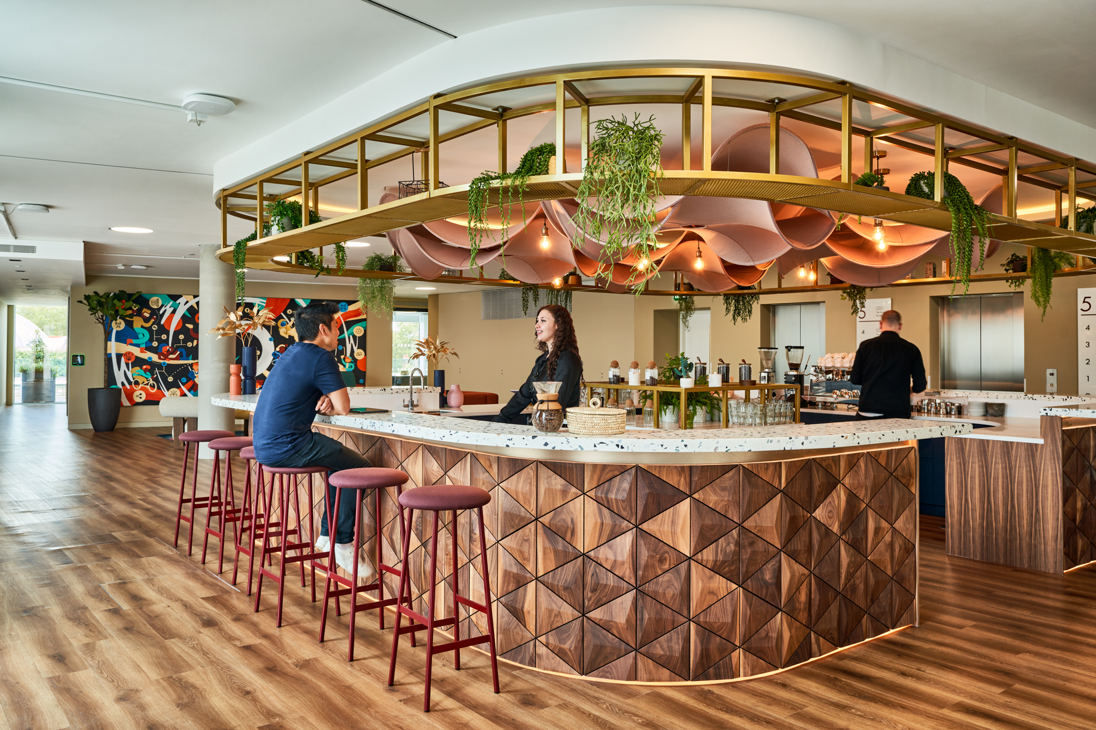 A stylish barista bar in the Publicis Sapient office, with a unique wood-panelled design and green accents. This social hub is a central feature that promotes employee interaction and wellbeing.