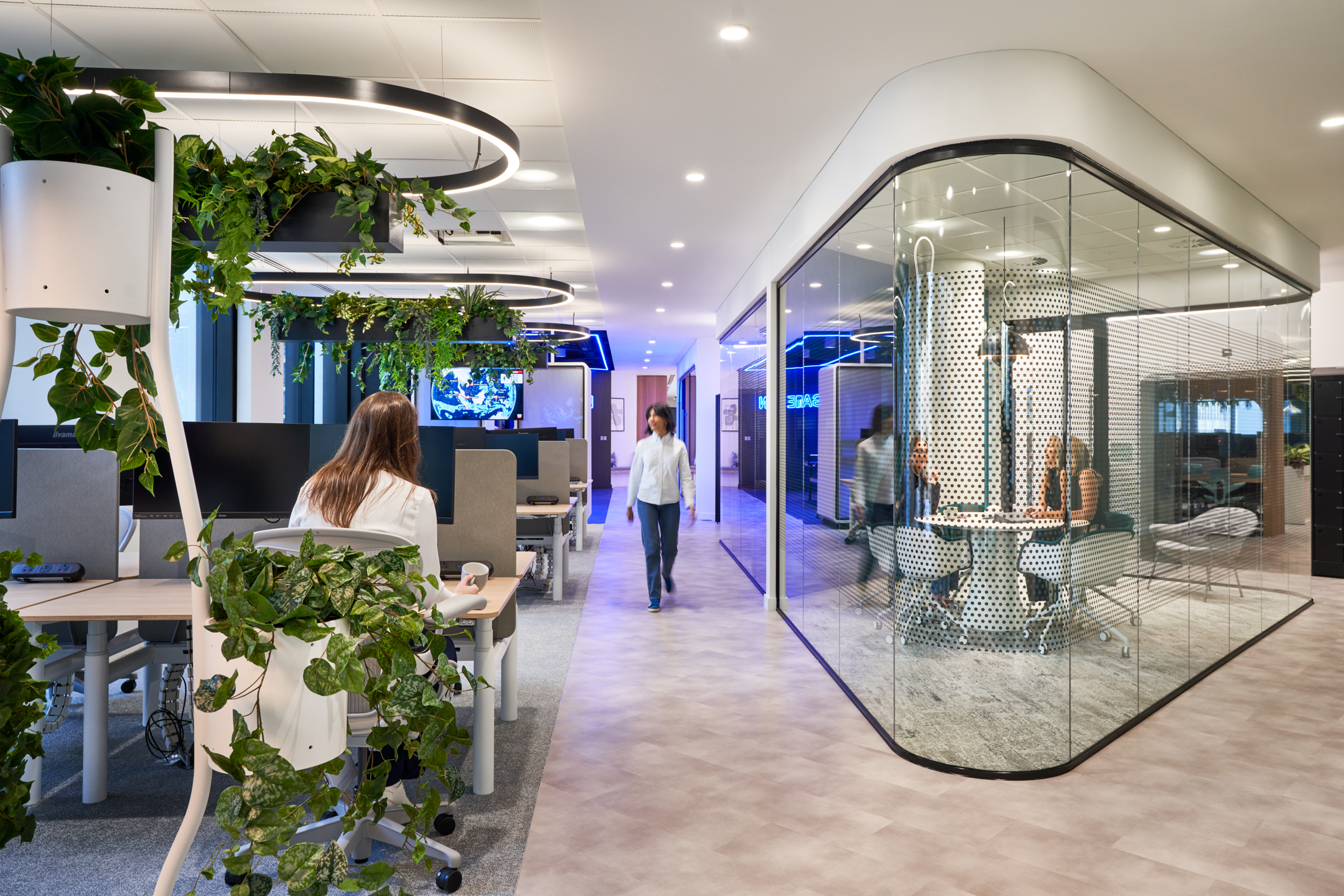 Capital.com's open-plan workspace integrates greenery with contemporary workstations and sleek glazing meeting rooms, creating a dynamic and engaging environment for collaboration and productivity while allowing natural light to flow through.