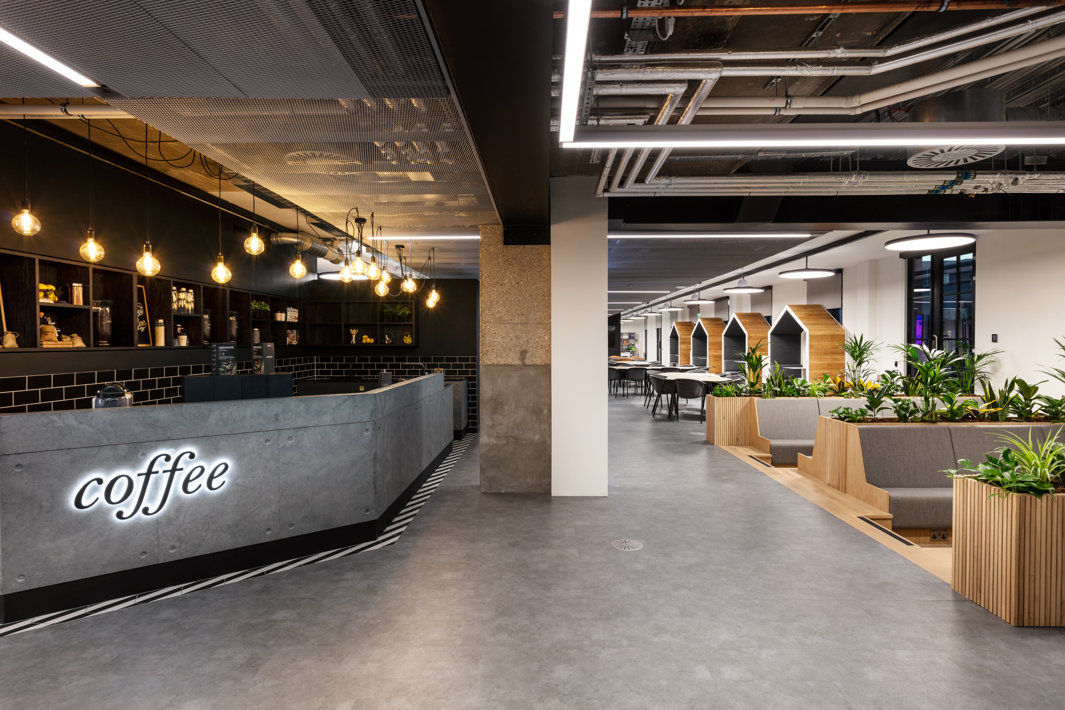 : A modern coffee area in the Checkout.com office, designed by Modus Workspace, featuring a concrete counter with a neon 