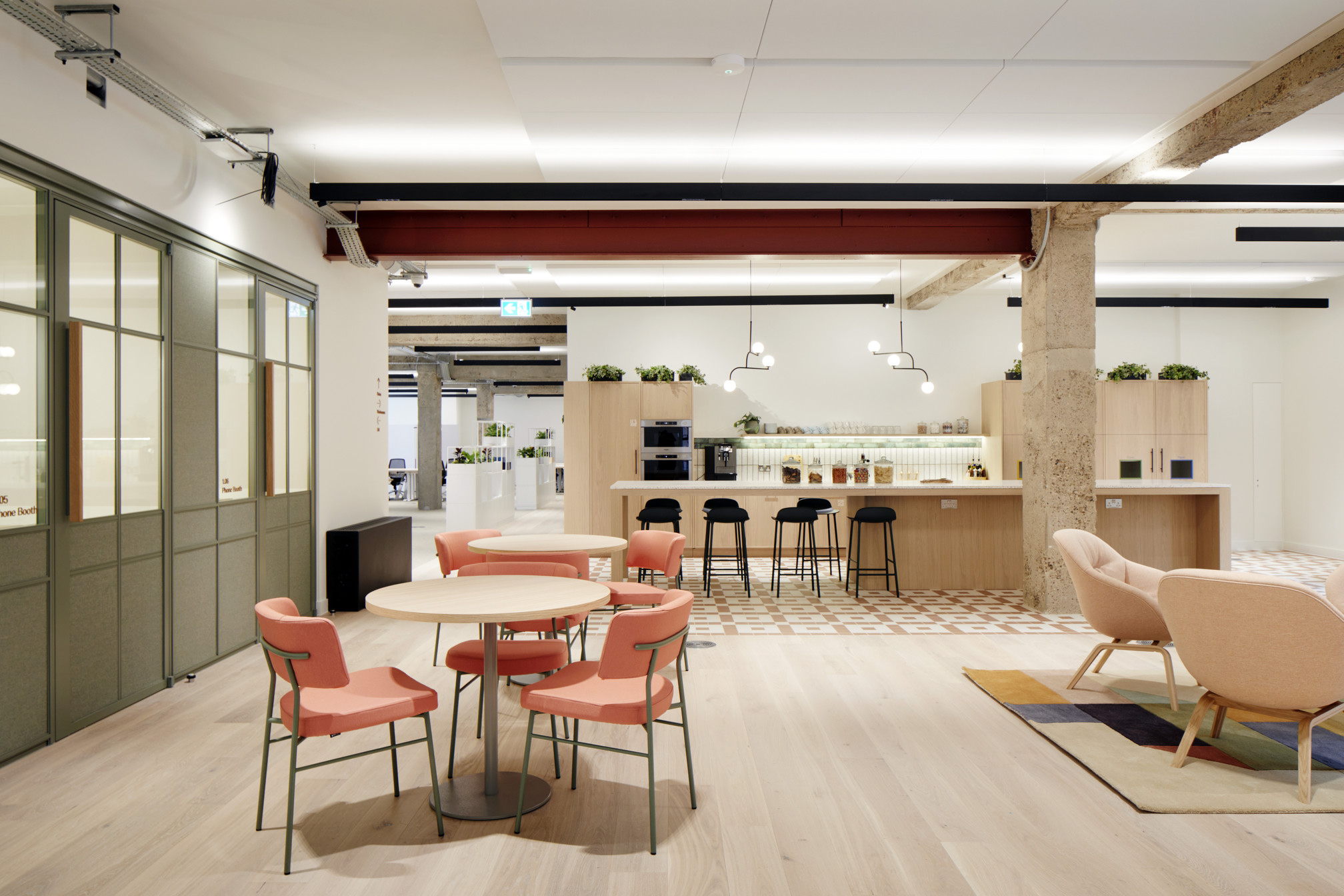 Modern co-working kitchen and dining area at Fora Greencoat Place, designed by Modus. The space combines industrial elements with soft furnishings, offering a welcoming atmosphere for breaks and informal meetings.