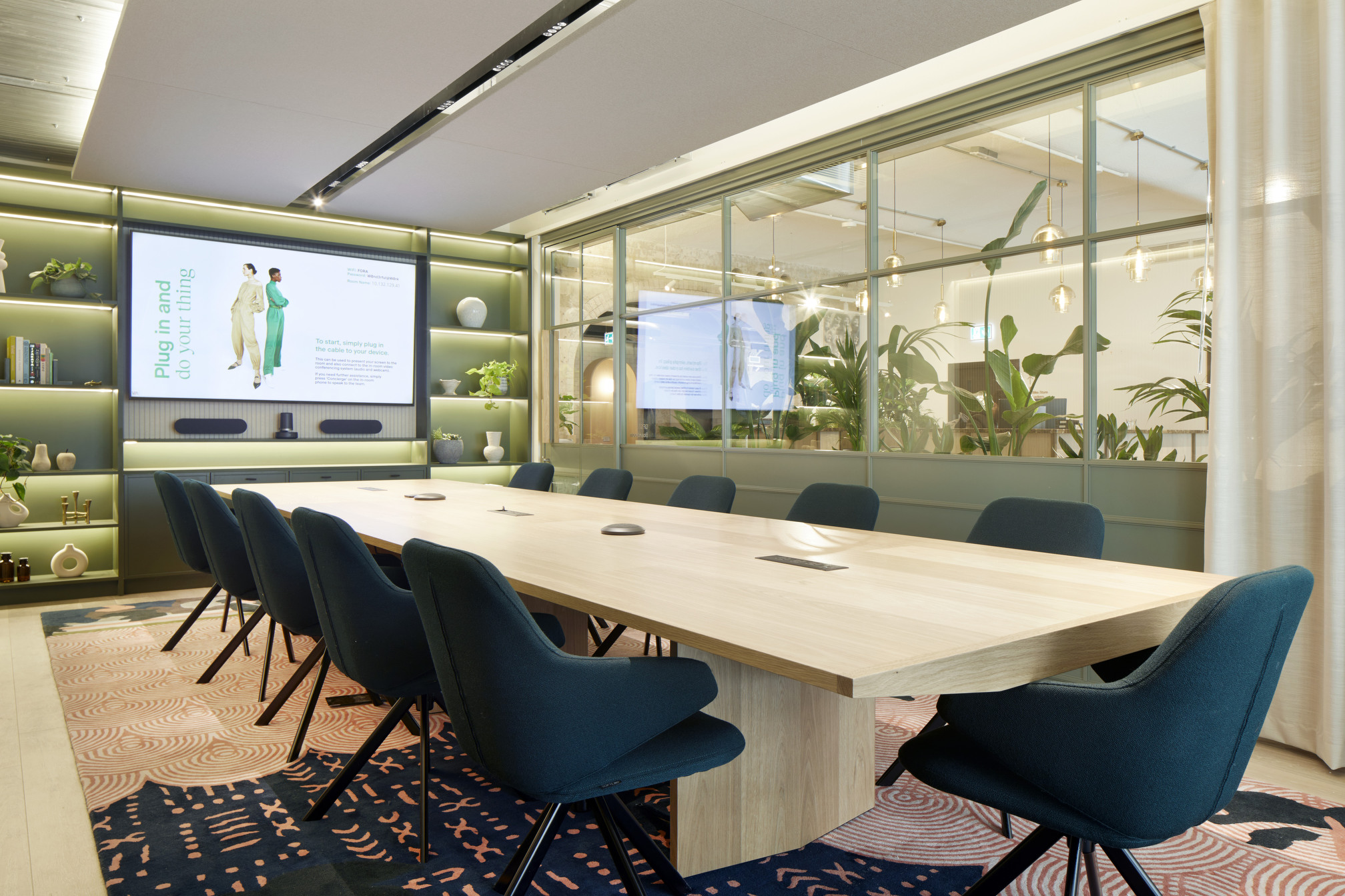 State-of-the-art boardroom within the Fora Greencoat Place co-working space, designed by Modus. The room features a large central table, advanced AV equipment, and a stylish, plant-filled environment, ideal for formal meetings.