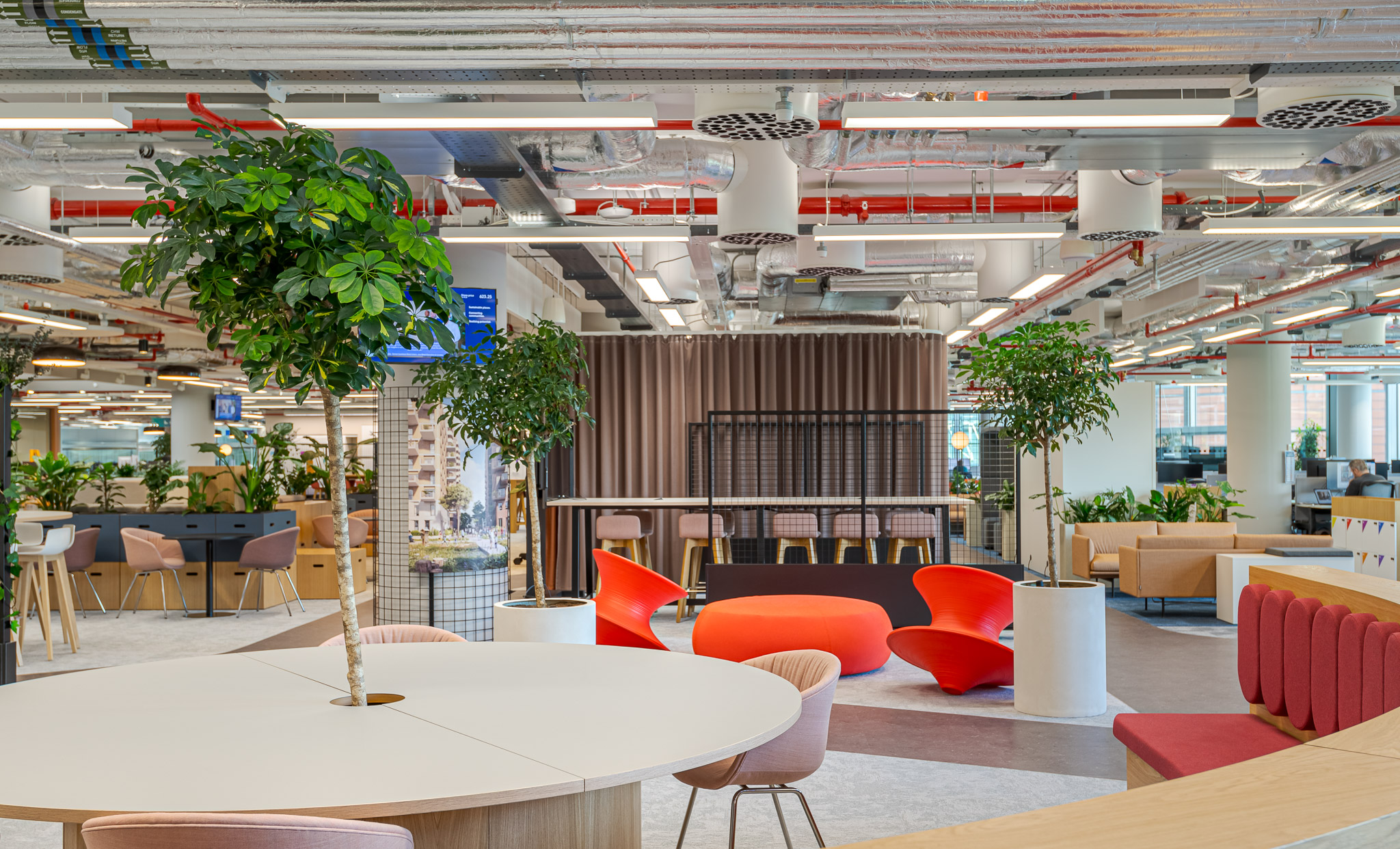 Modern open-plan workspace at Landsec 100 Victoria Street Headquarters, designed by Modus Workspace. The space features greenery, contemporary seating, and exposed ceilings, creating a vibrant and collaborative office environment.