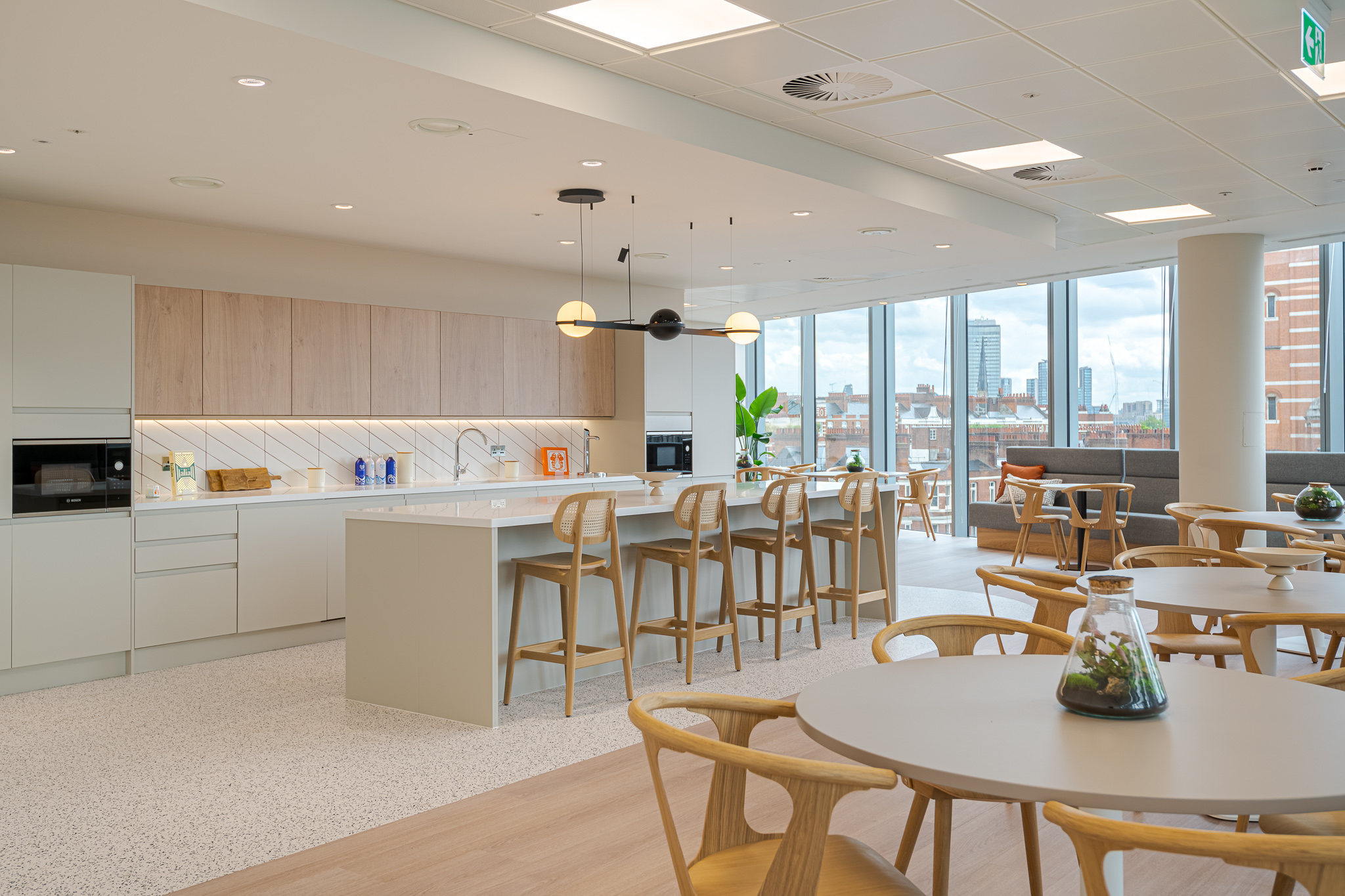 Spacious tenant-ready kitchen and dining area at Landsec 100 Victoria Level 6, designed by Modus Workspace, featuring a central island, modern appliances, and seating areas with views of the city, designed for tenant convenience and comfort.