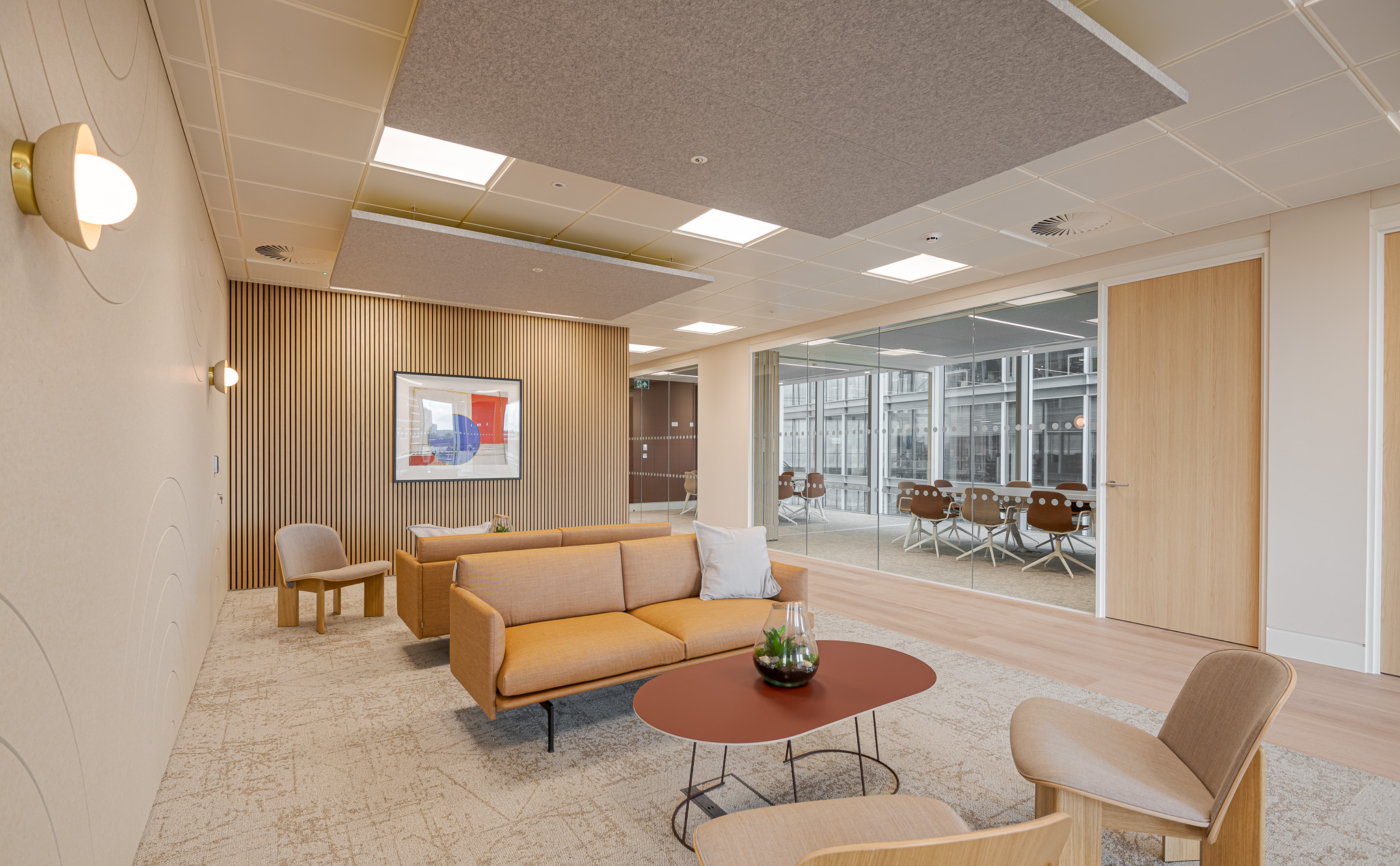 Contemporary tenant-ready meeting space at Landsec 100 Victoria Level 6, designed by Modus Workspace, featuring a comfortable lounge area with stylish furniture and a view into a connected glass-walled meeting room, ideal for formal and informal gatherings.