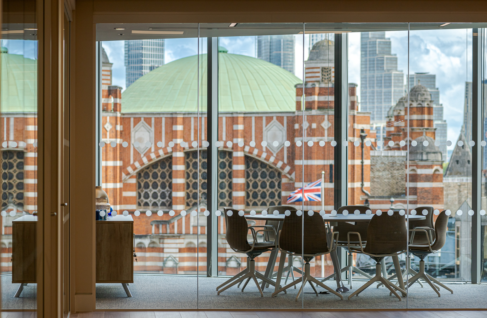 Tenant-ready meeting room at Landsec 100 Victoria Level 6, designed by Modus Workspace, with stunning views of London’s iconic architecture. The space is designed with modern chairs and tables, enclosed in glass walls, ideal for professional discussions.