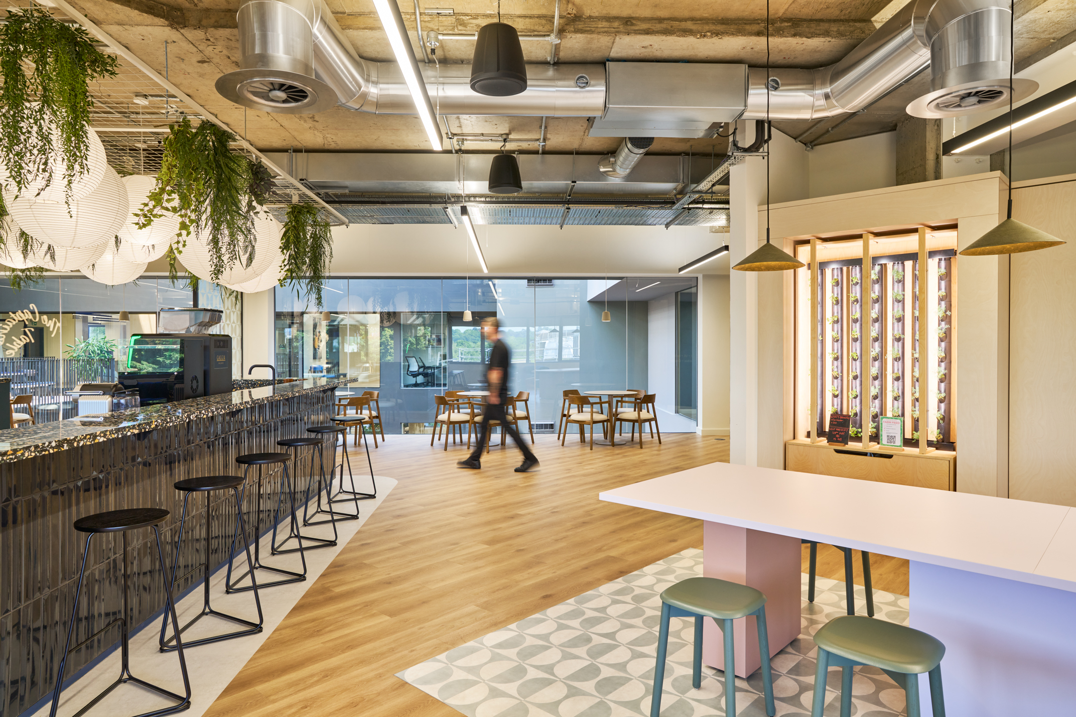 A view of the bar at Nomad Foods, where organic elements blend with industrial design, creating a perfect mix of modern aesthetics and comfort for employees.