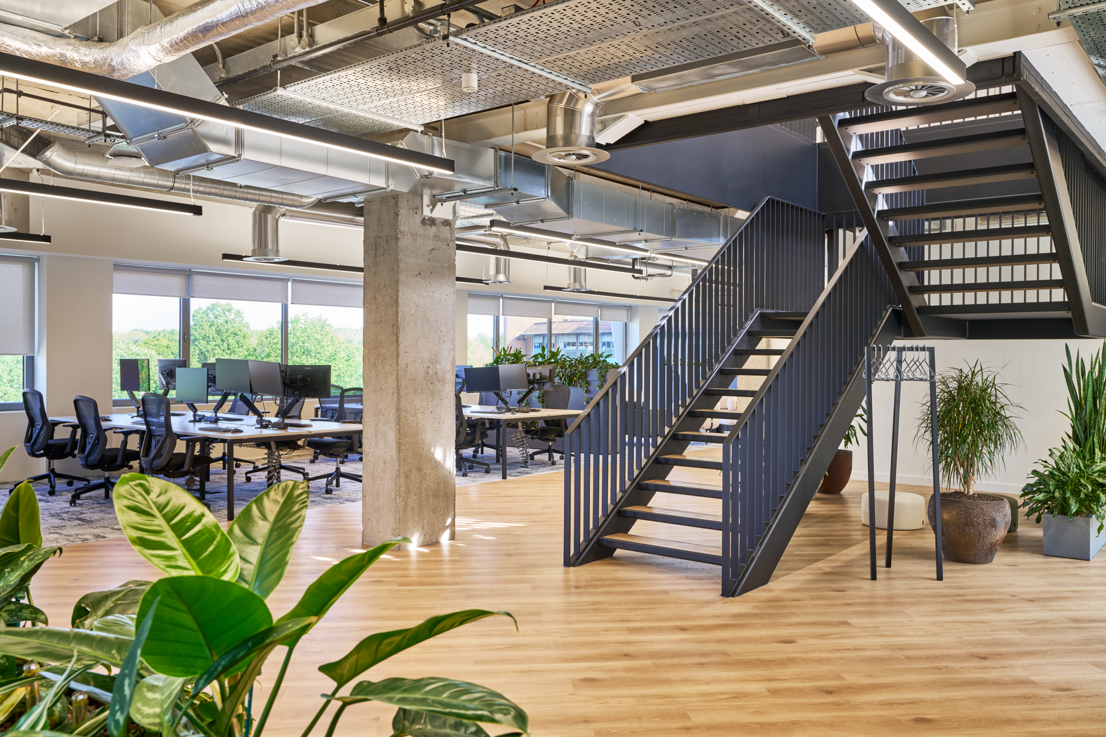 A spacious open office area at Nomad Foods, with a central staircase and ample natural light, encourages collaboration and productivity.