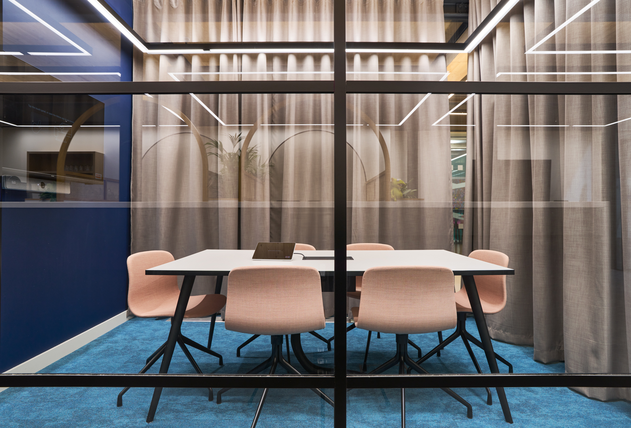 This meeting pod at Nomad Foods offers a comfortable and modern space for focused collaboration, with a calming blue and soft pink colour palette.