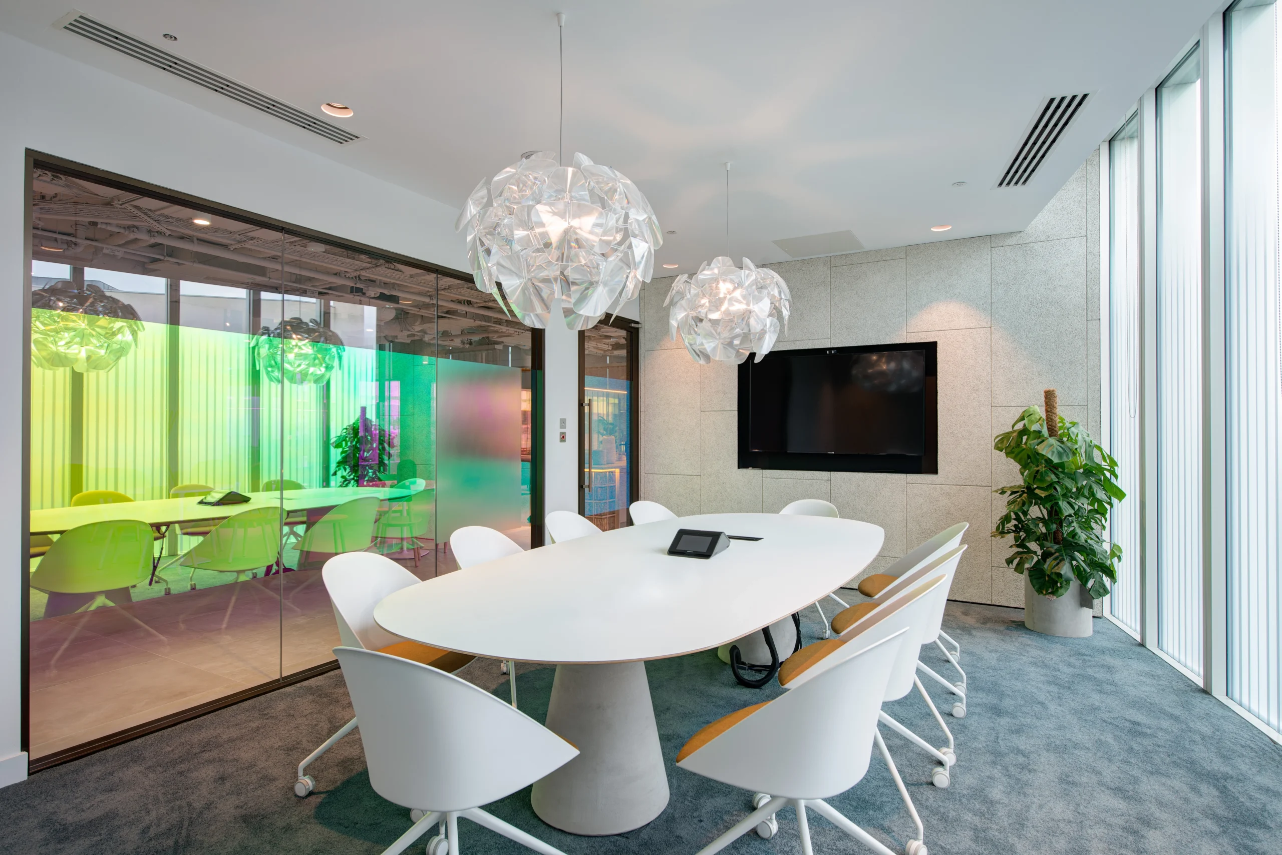 Stylish conference room at Storey - 2 Kingdom Street, designed by Modus Workspace. The room is equipped with sleek white furniture, artistic hanging lights, and colourful glass partitions, making it perfect for professional meetings with a creative twist.