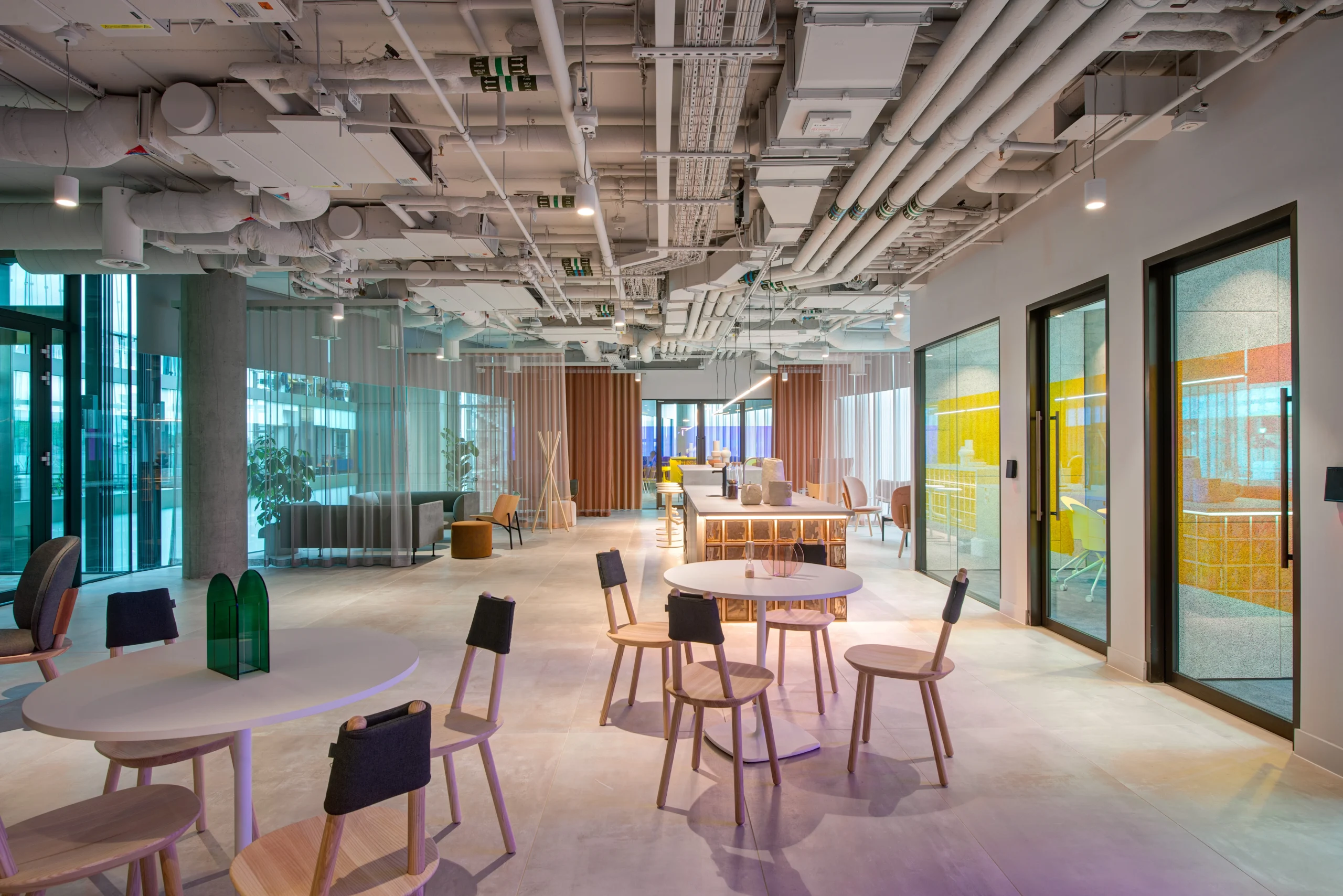 Quiet work lounge at Storey - 2 Kingdom Street, designed by Modus Workspace. Comfortable seating is paired with modern, stylish lighting, and large windows that offer a view of the surrounding building, fostering productivity and focus.