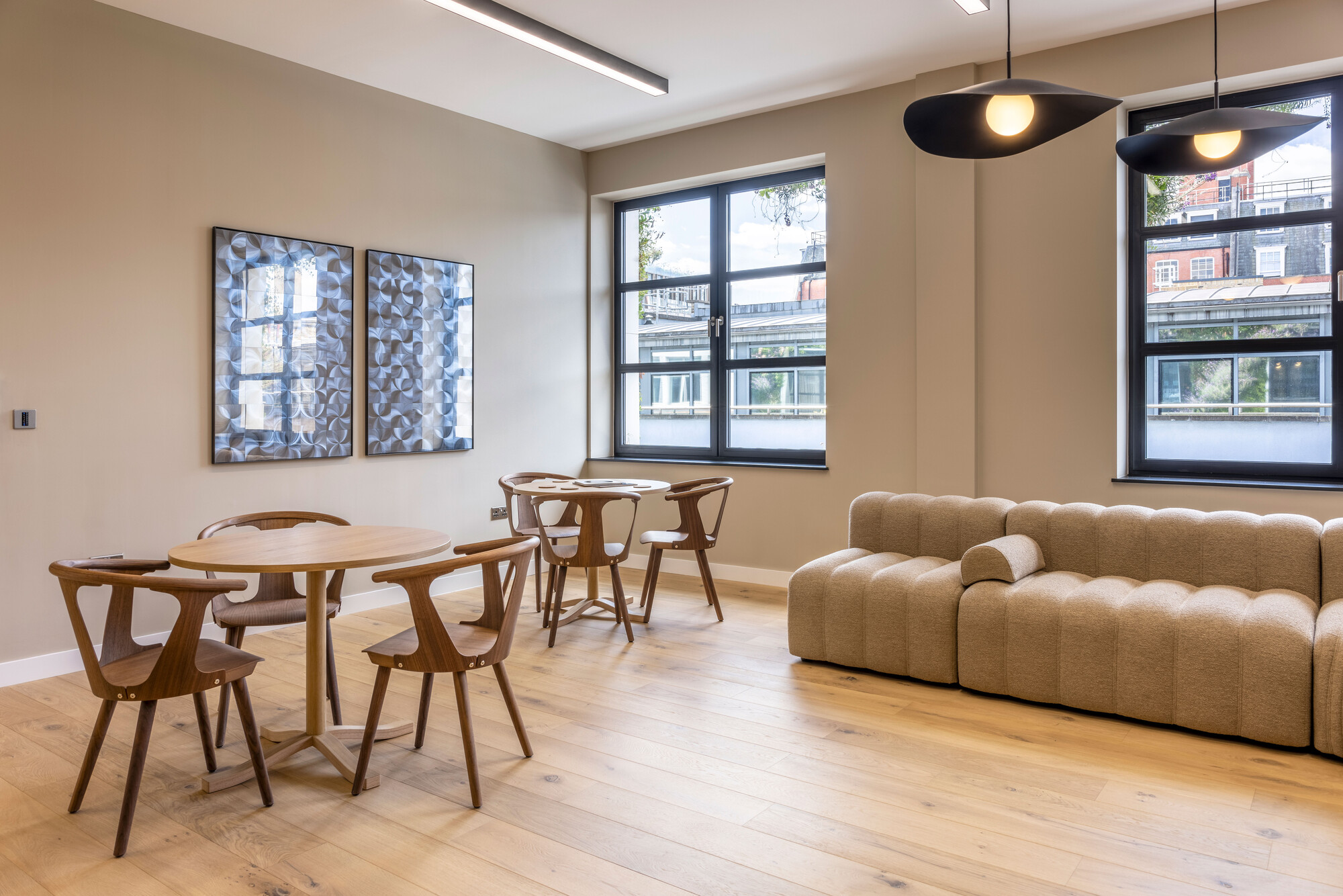 Transition designed by Two Workspace, featuring a Scandinavian decorated space with a beige cloud couch, and seating area