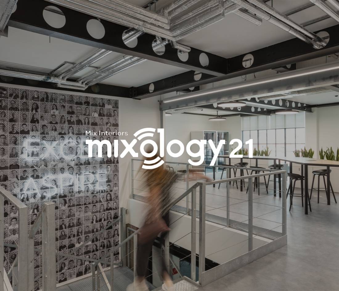 Checkout.com workspace featuring industrial ceilings, a staircase, and collaborative seating. A finalist for the Mixology Awards 2021, showcasing modern office design.