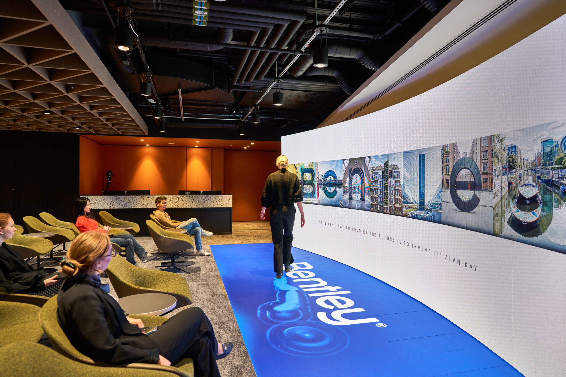 Office space at Bentley Systems featuring seating area and a large floor-to-ceiling display screen