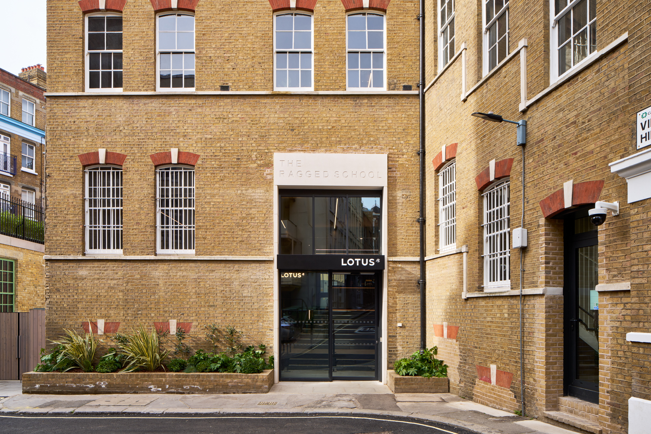 The main entrance to Lotus's new headquarters, located in the historic Ragged School in Clerkenwell. Modus has preserved the original brick façade while introducing modern design elements.