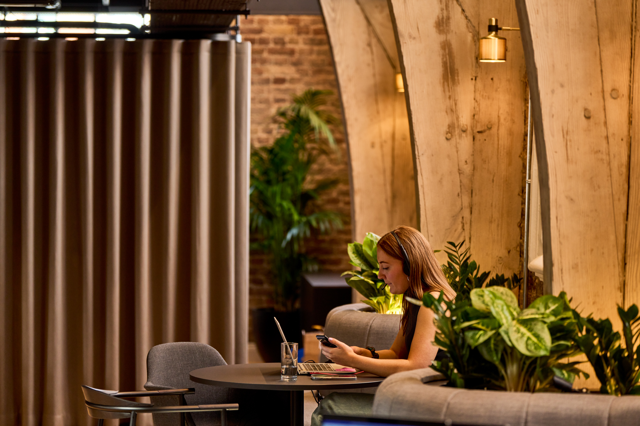 A quiet workspace at Lotus headquarters, designed by Modus, with exposed wooden beams and soft lighting, retaining the historic character of the Ragged School.