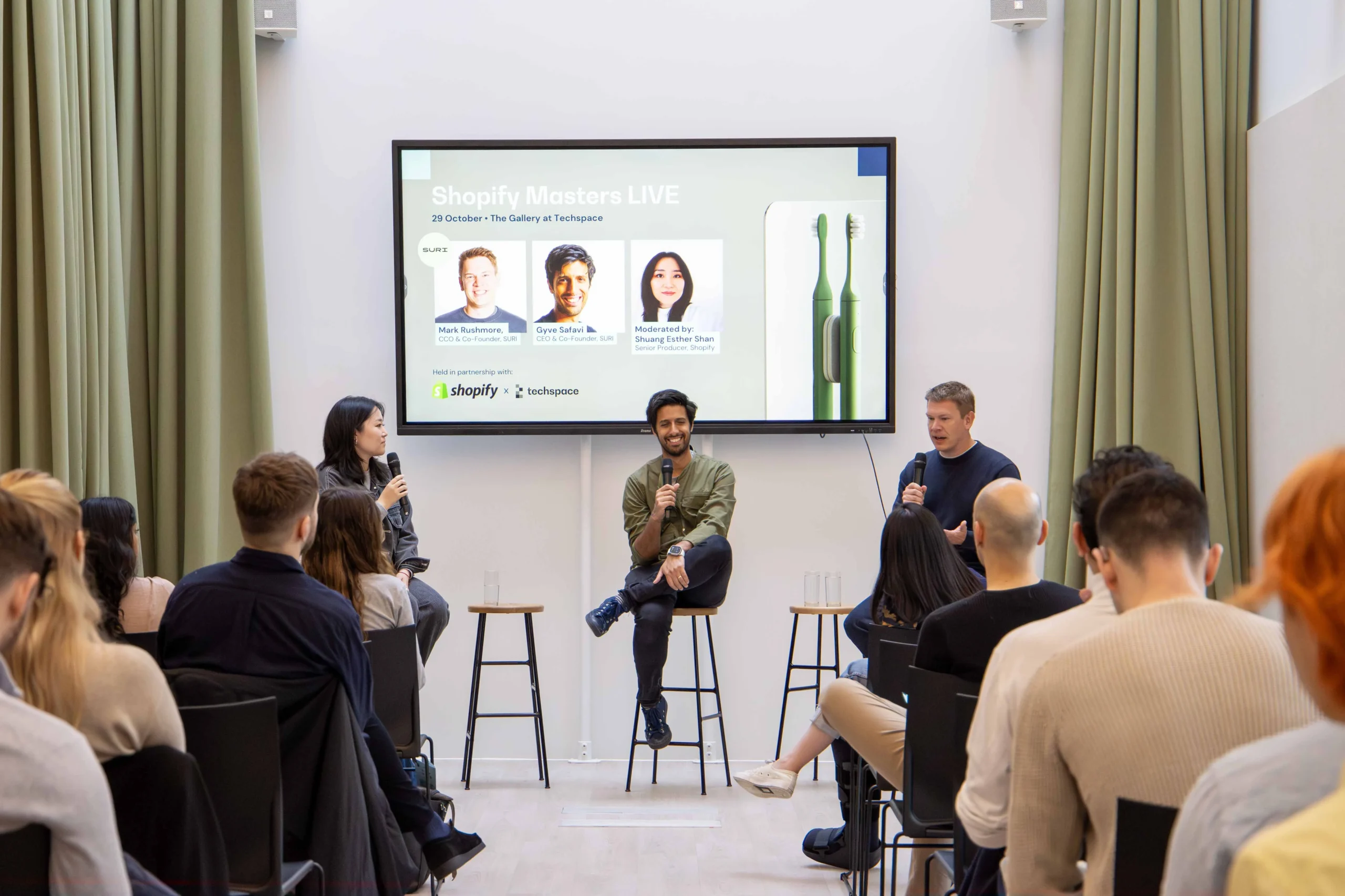 Techspace conference room with green curtains and a presentation being demonstrated