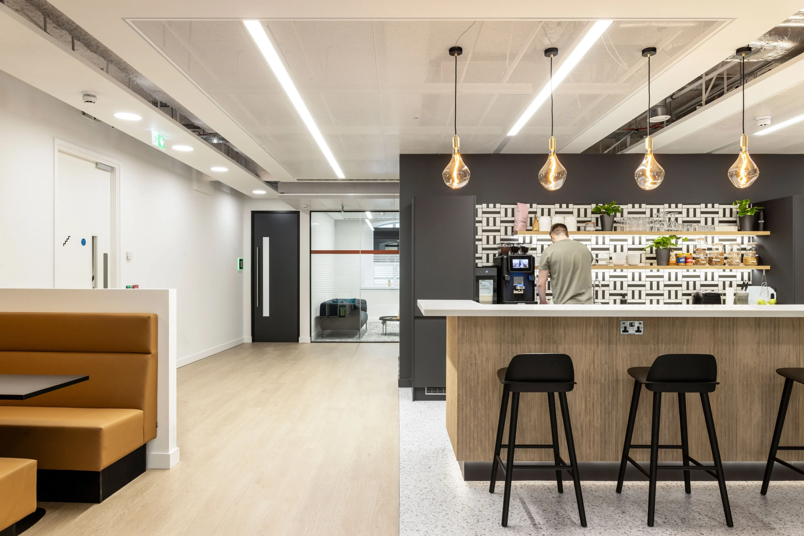 CCP Games' workspace featuring a modern teapoint with patterned backsplash, warm-toned seating booths, and pendant lighting for a welcoming atmosphere.