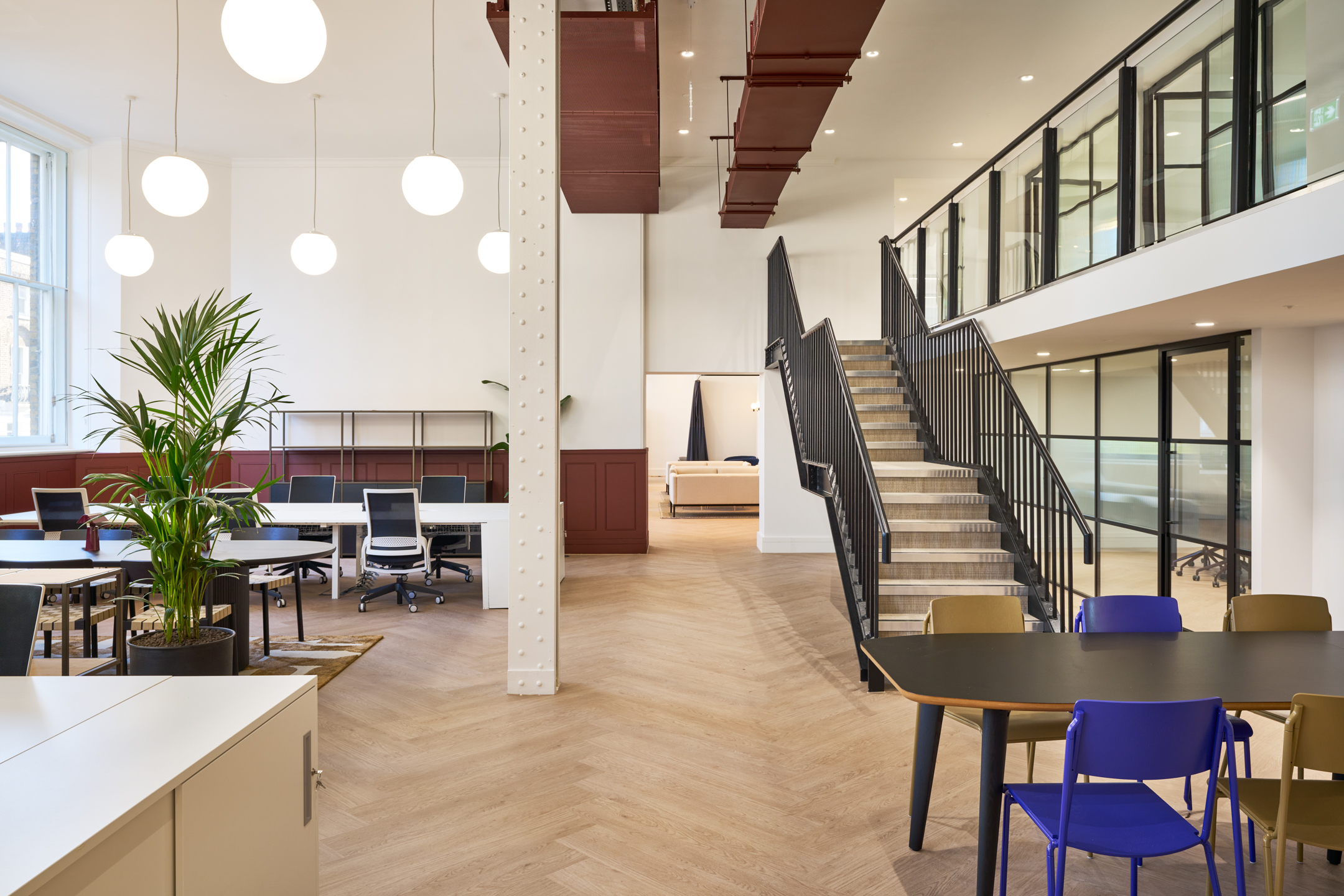 163-203 Eversholt Street's centrail staircase, hanging lights and open plan workspace