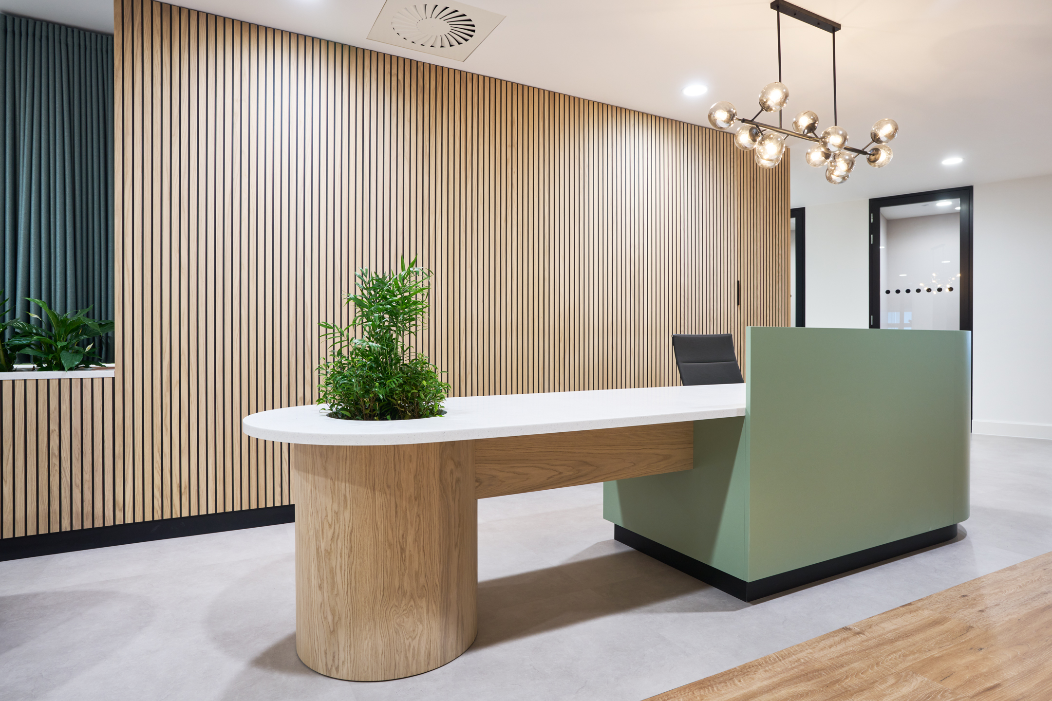 BentallGreenOak Recepting Area with Green Accents and a Wooden Desk