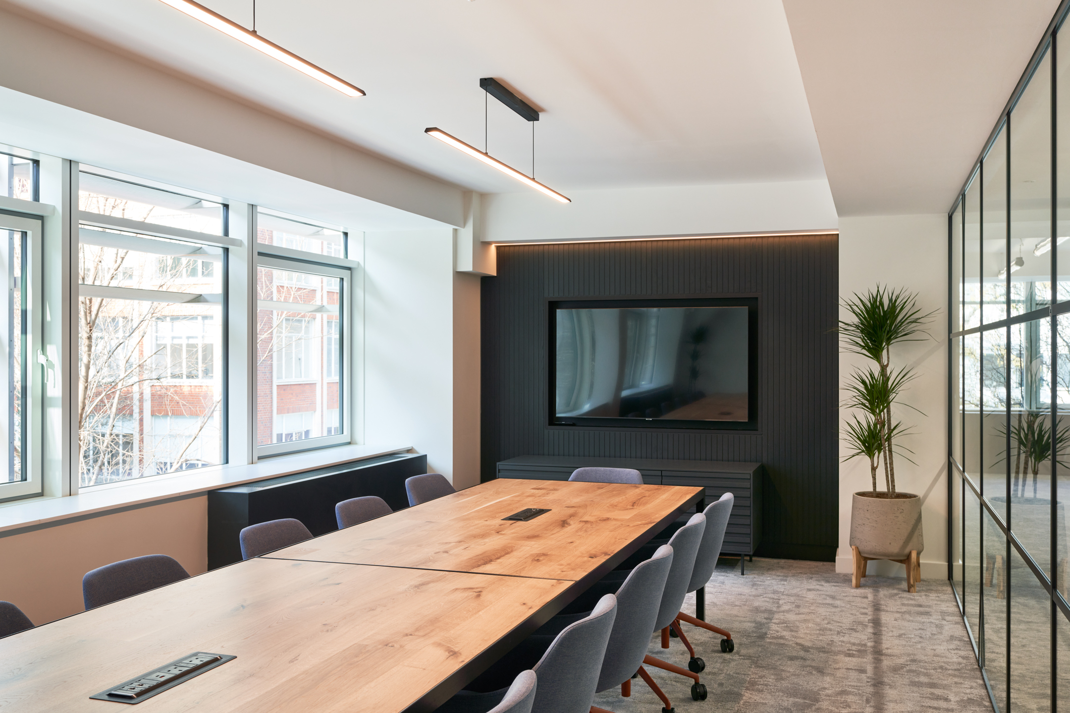 Meeting Room with Black Wall Mounting a TV Screen and a Table