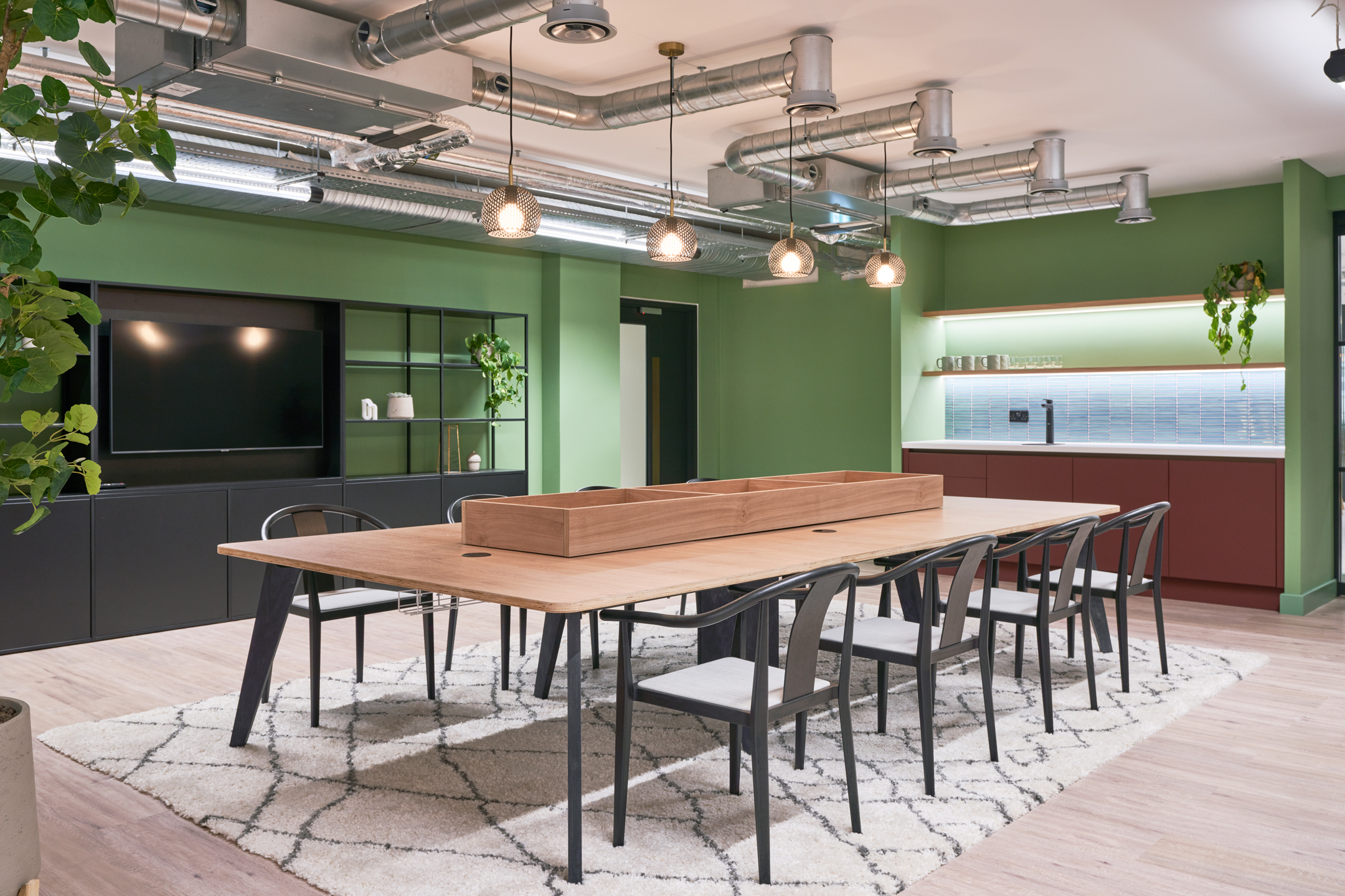 Teapoint at 101 NewCavendishSt featuring green walls, and an oak table with black chairs