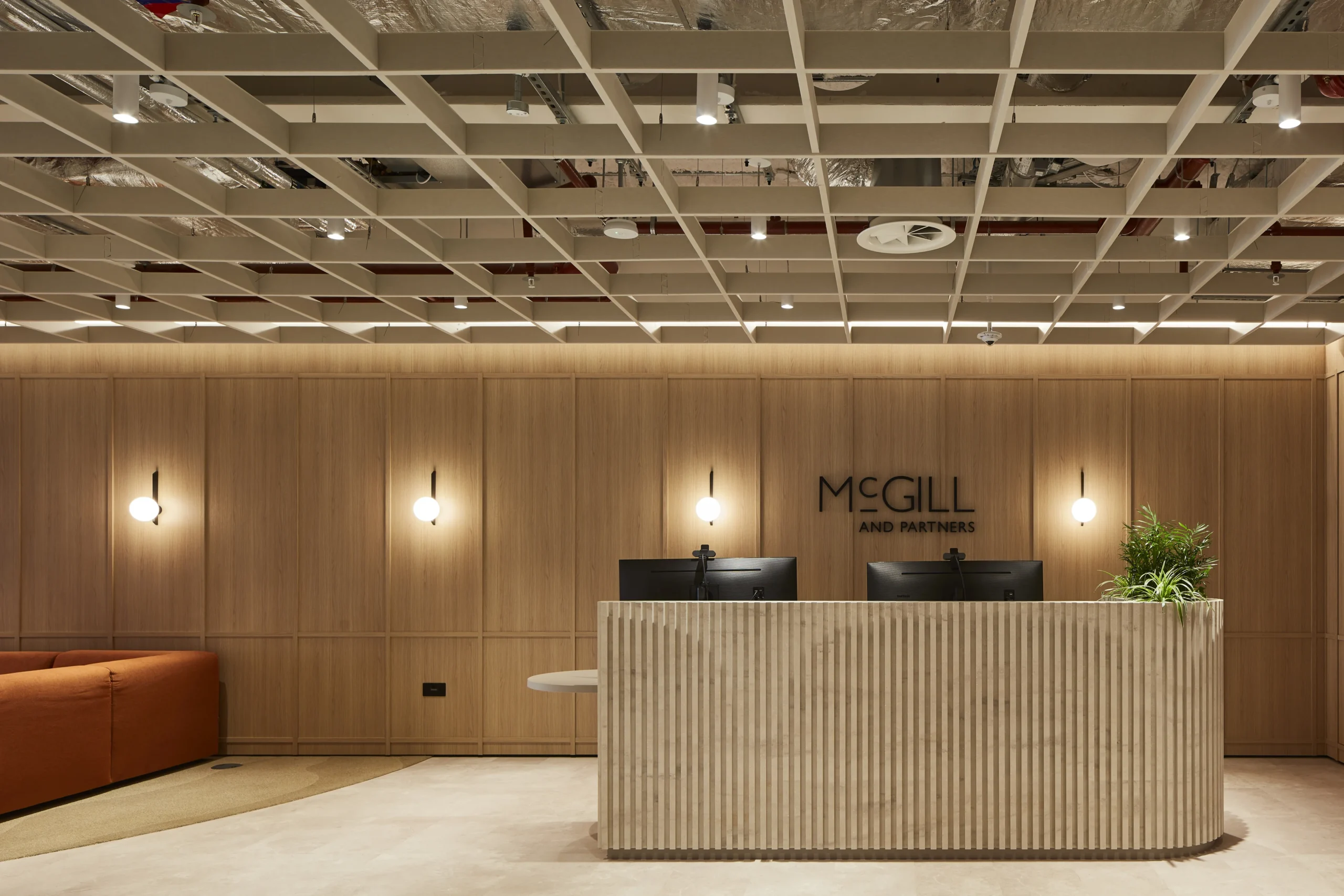 “Elegant reception area at McGill & Partners' office featuring sleek finishes and a welcoming, contemporary design.