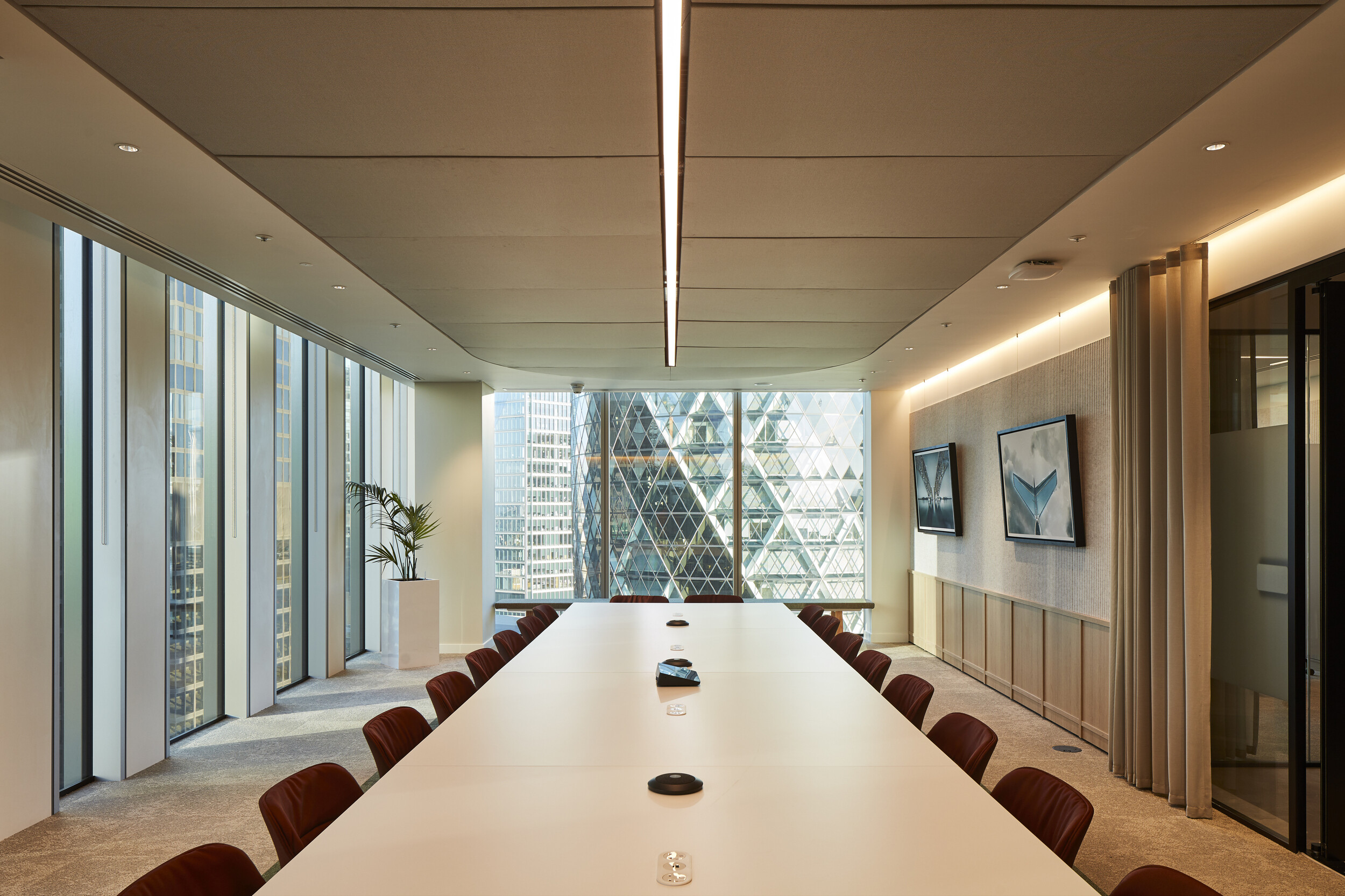 Sophisticated boardroom with floor-to-ceiling windows offering stunning views of the Gherkin and London skyline.