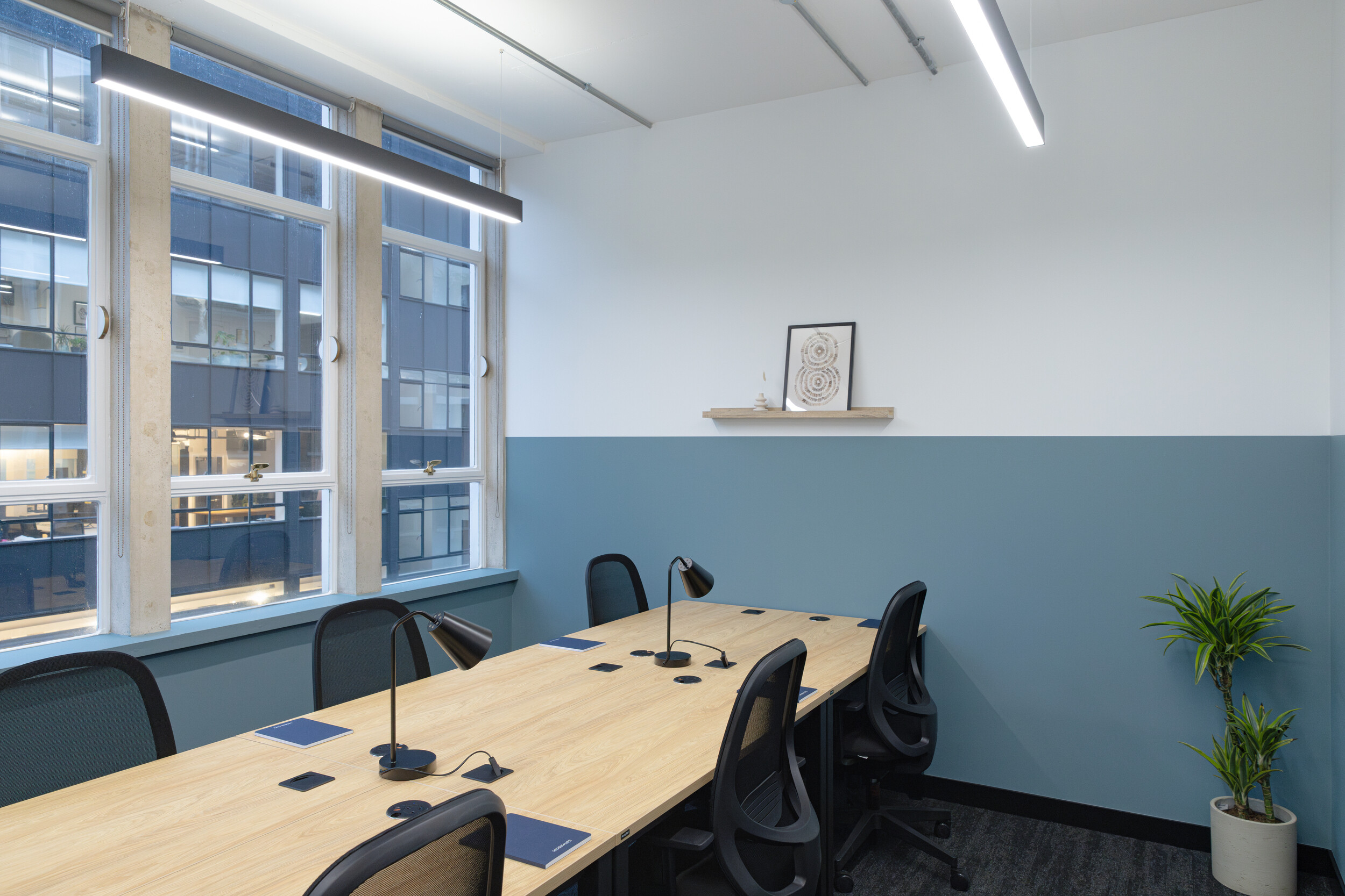 Modern meeting room with glass walls, ergonomic seating, and integrated AV technology for collaborative sessions.”