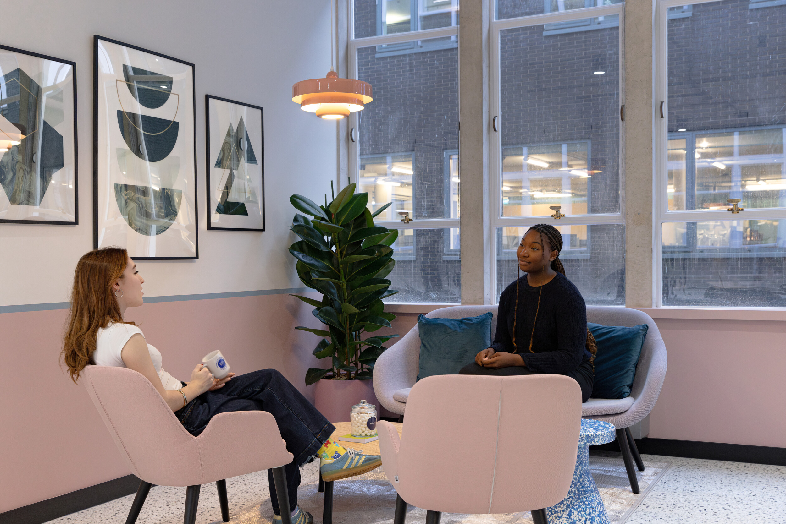 Relaxed breakout area with lounge-style seating and soft furnishings, designed to encourage informal collaboration and downtime.”