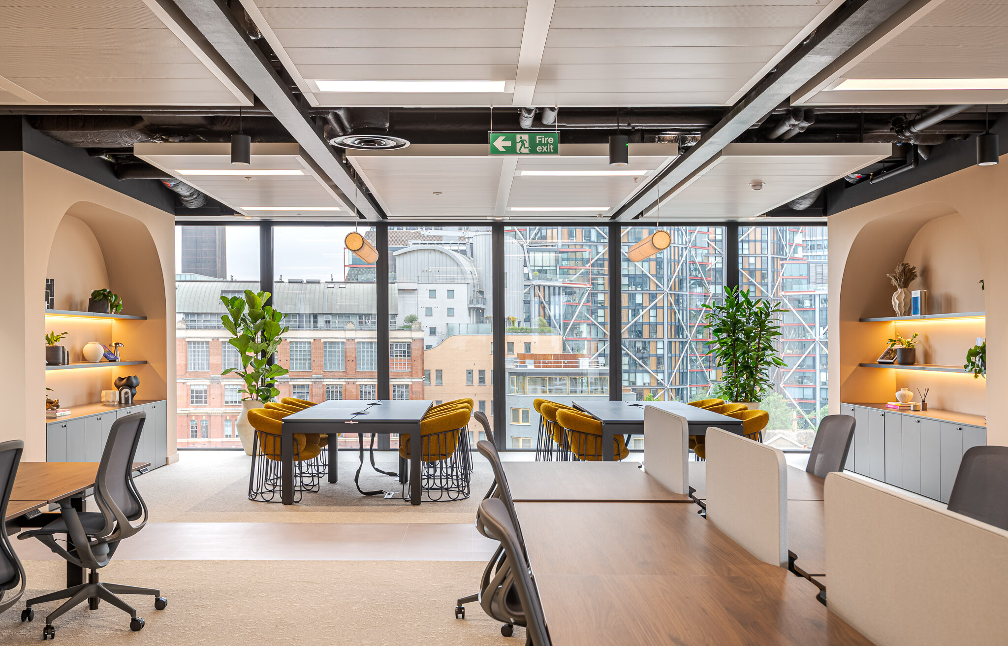 Workspace at Arbor with collaborative desks, arched shelving, floor-to-ceiling glazing and London cityscape views.