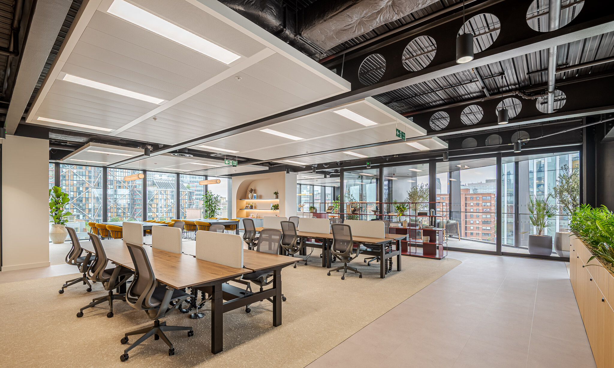 Arbor open-plan office with shared desks, lounge seating, burgundy shelving and terrace access.