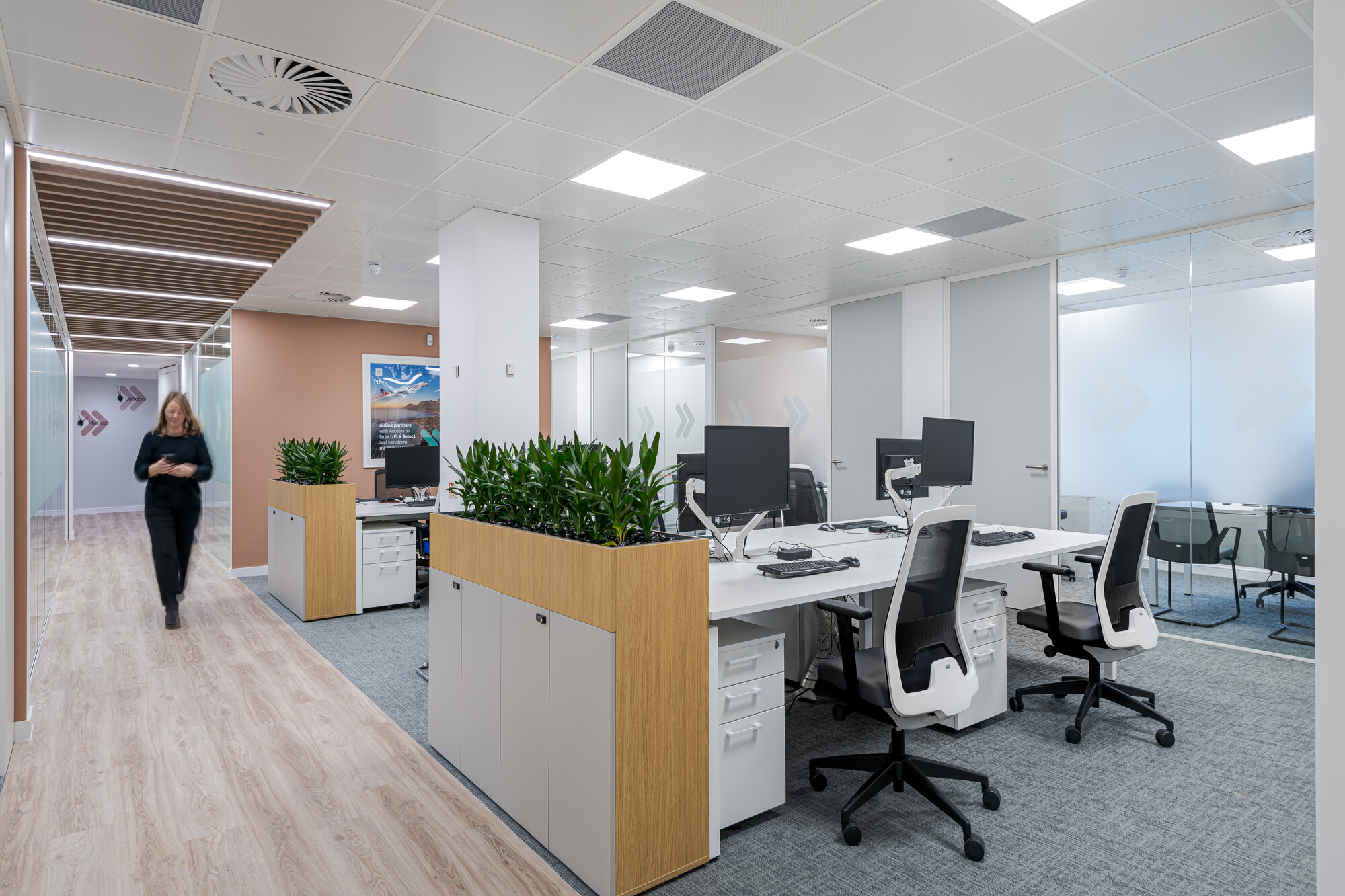 Open-plan workspace in Accelya's office by Two, with rows of white desks equipped with monitors and ergonomic chairs.