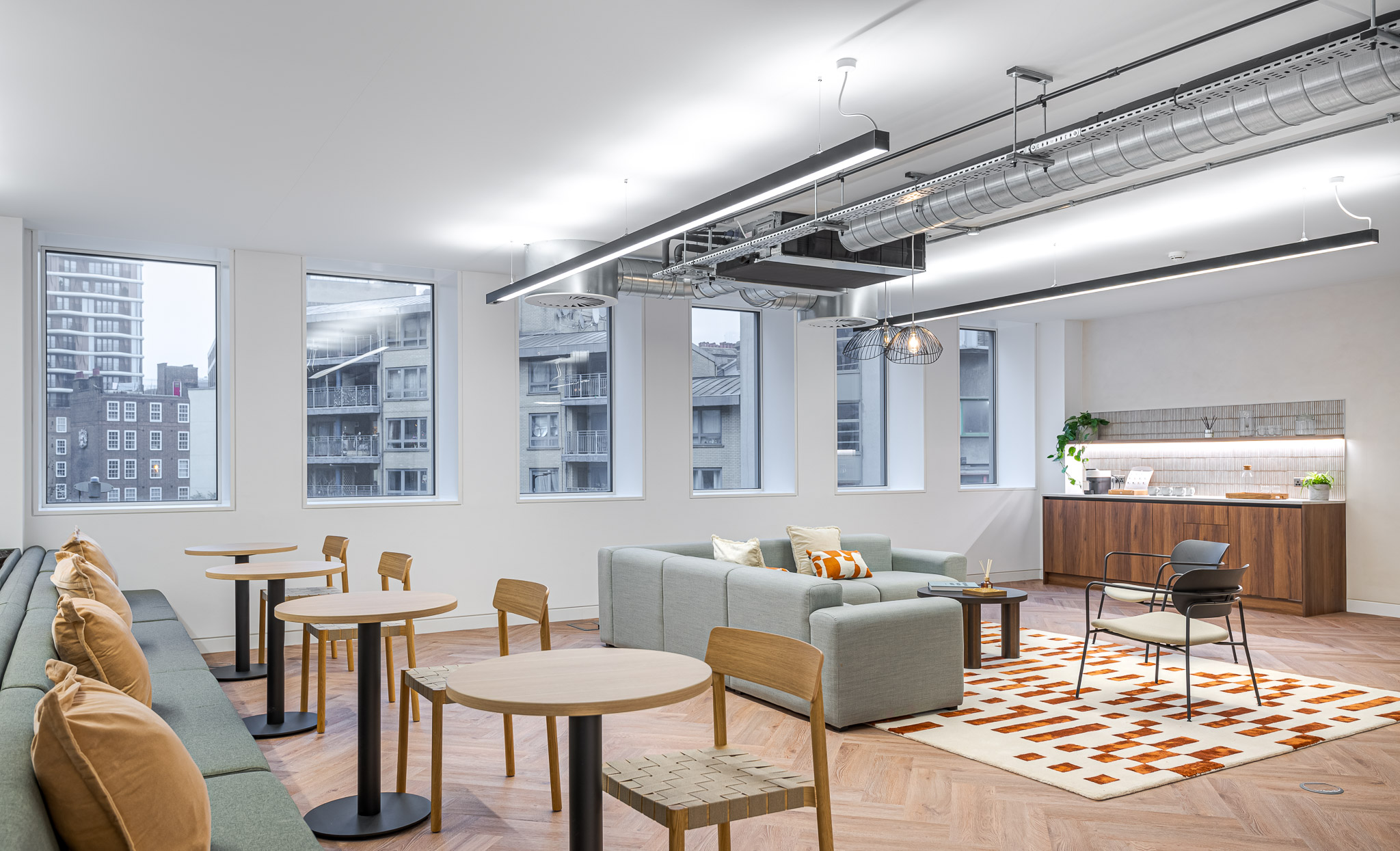 Tenant-Ready™ Lounge and teapoint area in the Asset Management Firm's Tenant-Ready™ space, combining soft seating, casual tables, and a timber kitchenette with city views and natural light.
