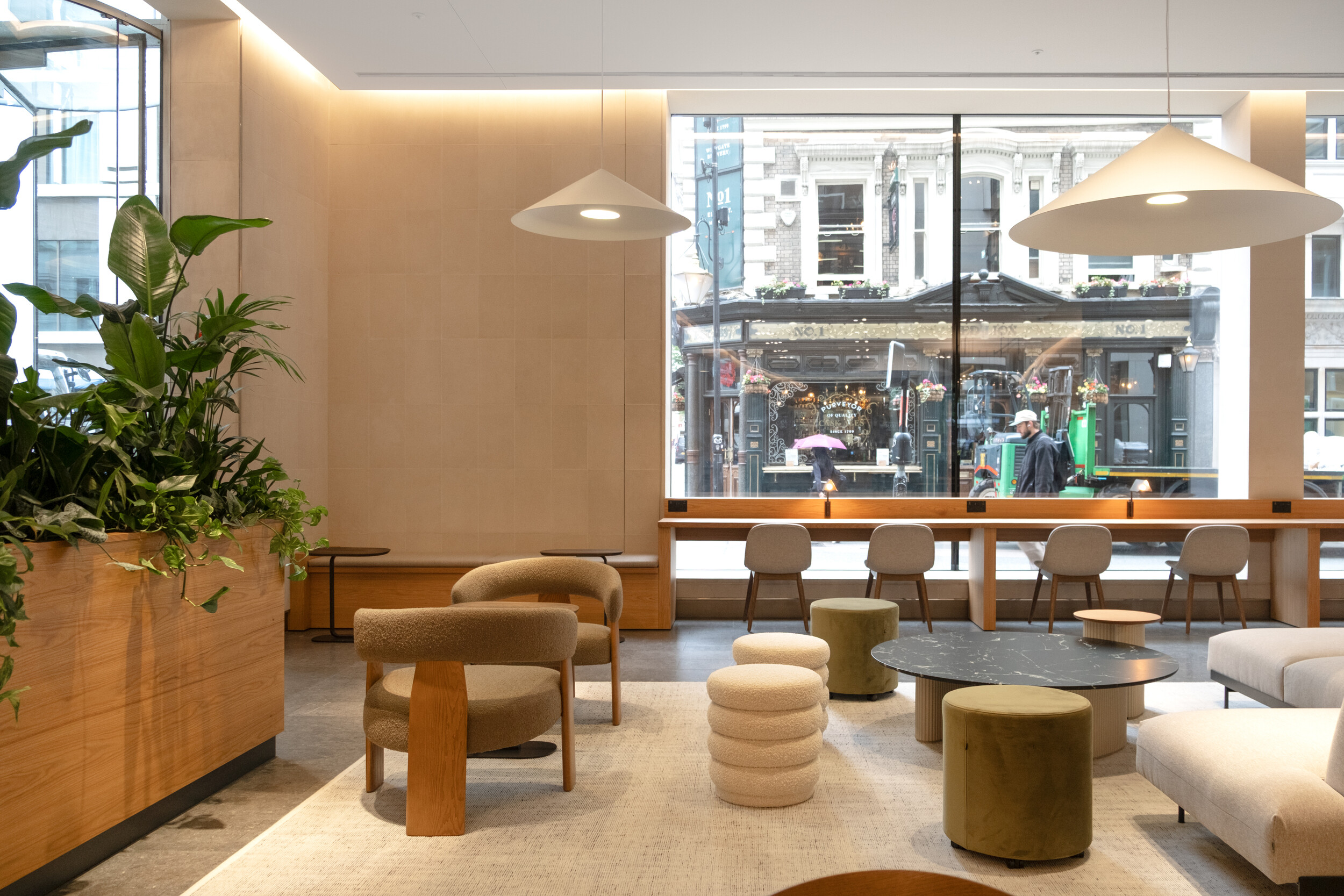 Contemporary lounge area at Finsbury Circus House with soft seating, marble coffee tables, and large windows offering views of the street outside
