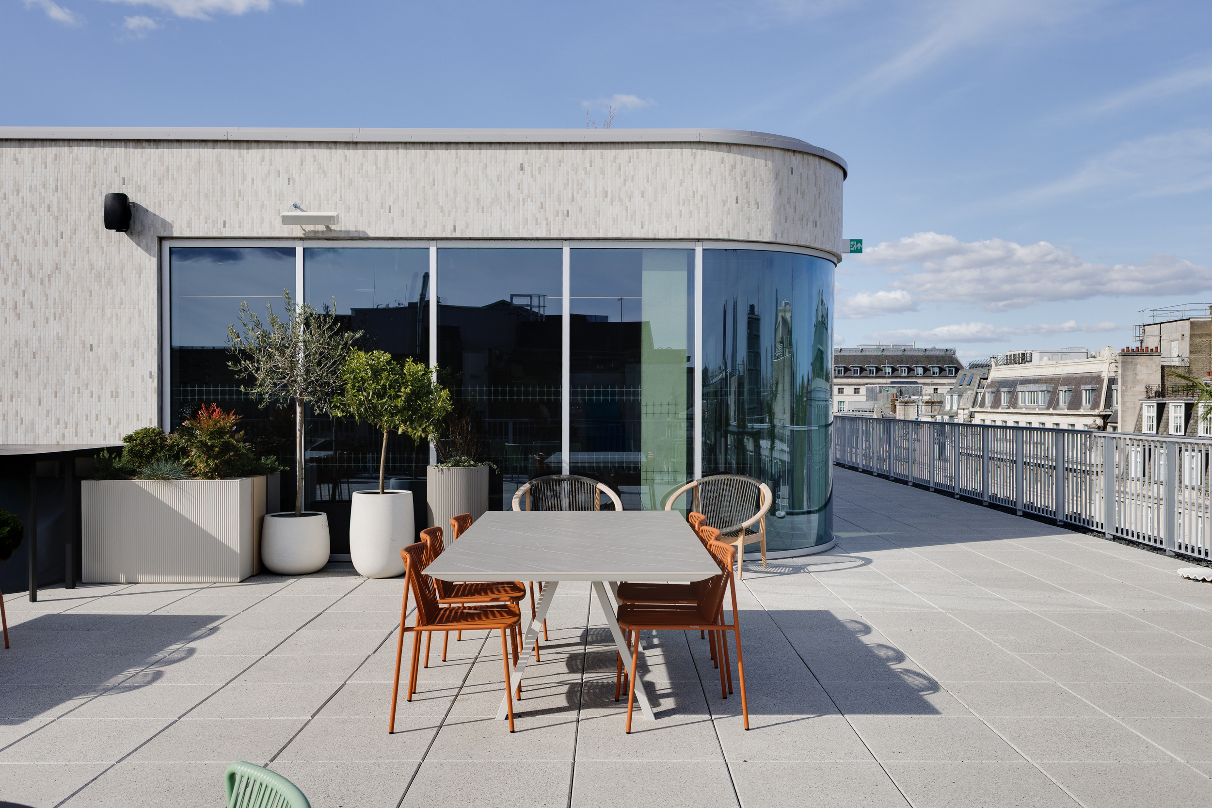 Terrace at the Space House Clubhouse featuring a contemporary dining setup with terracotta chairs and potted greenery, reflecting Modus and Platfform’s modern approach to outdoor workspace design.