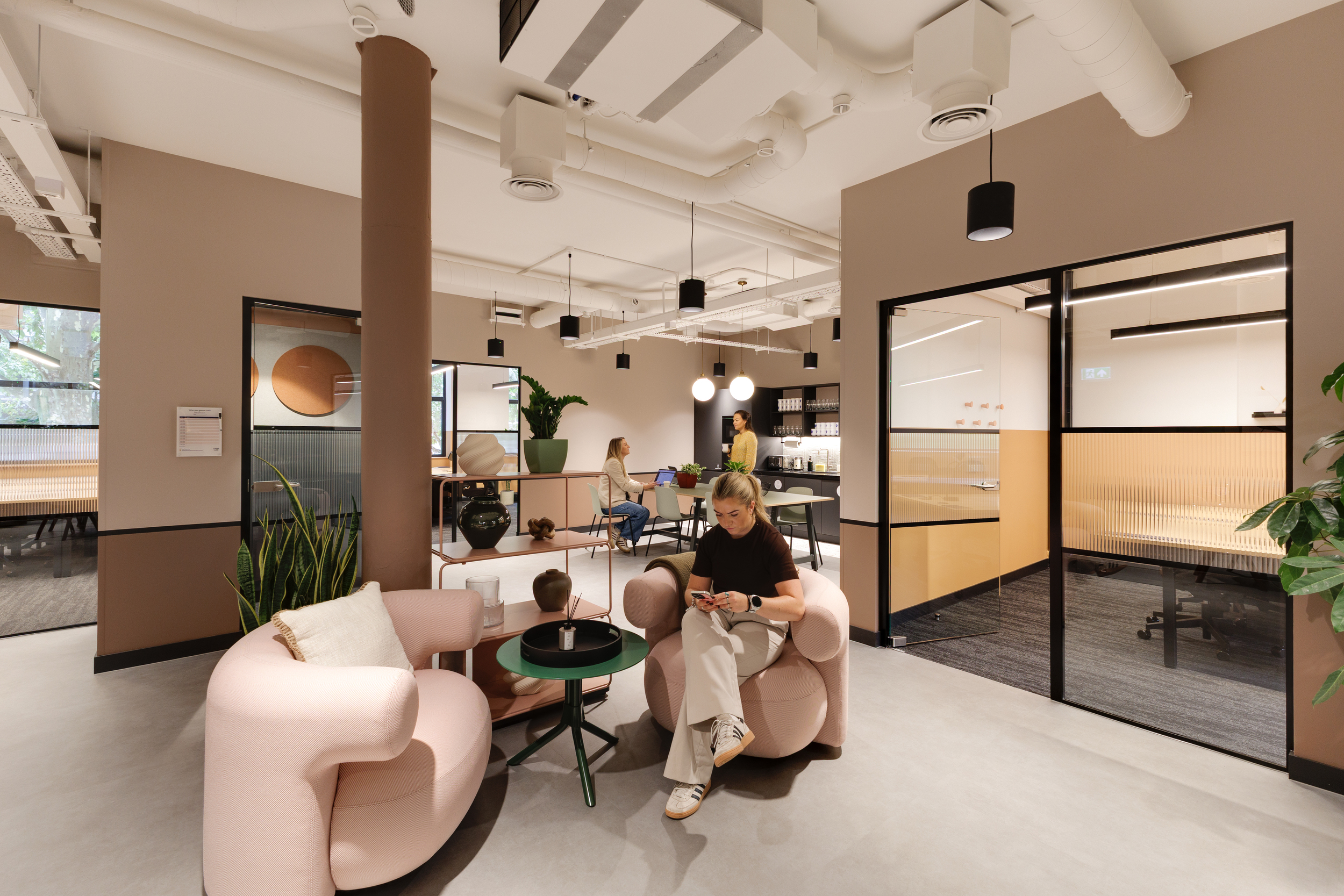Lounge area at Work.Life Clerkenwell Green with blush pink seating, warm lighting and open meeting rooms, showcasing the modern coworking environment shaped through Two and Platfform’s collaboration.
