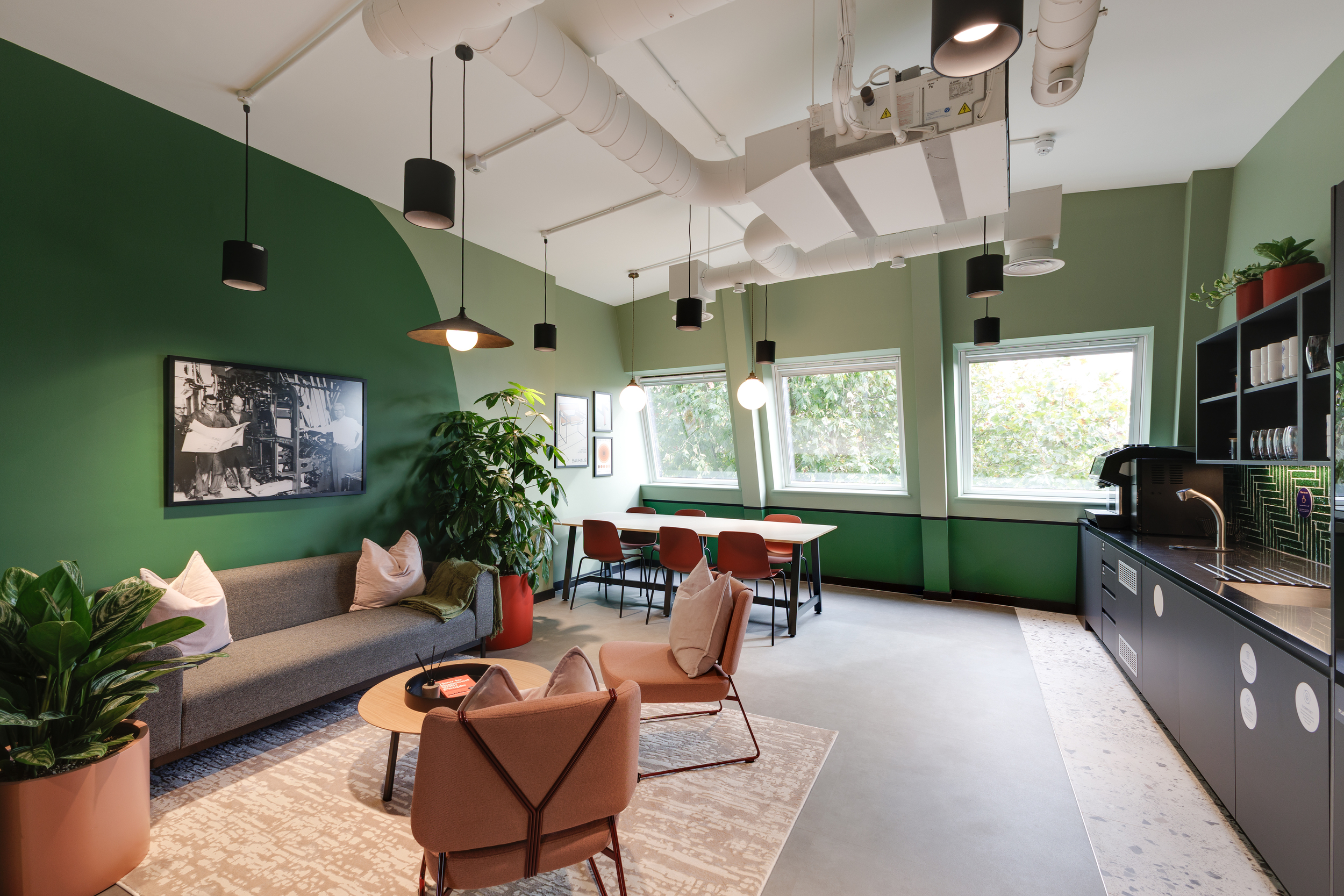 Teapoint and lounge at Work.Life Clerkenwell Green with green walls, terracotta seating and biophilic touches, reflecting the modern coworking design developed through Two and Platfform.